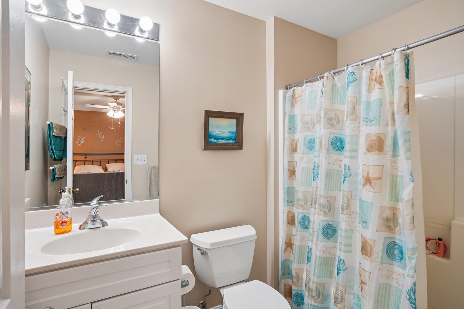 A bright, cheerfully decorated bathroom with coastal-themed accents awaits your arrival. Fresh towels and a well-lit vanity make preparing for your day effortless and pleasant.
