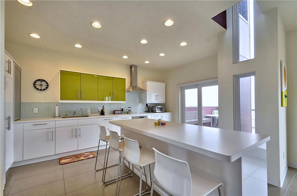You'll love gathering in this bright, modern kitchen with sleek countertops, plenty of prep space, and an island perfect for casual meals or morning coffee.