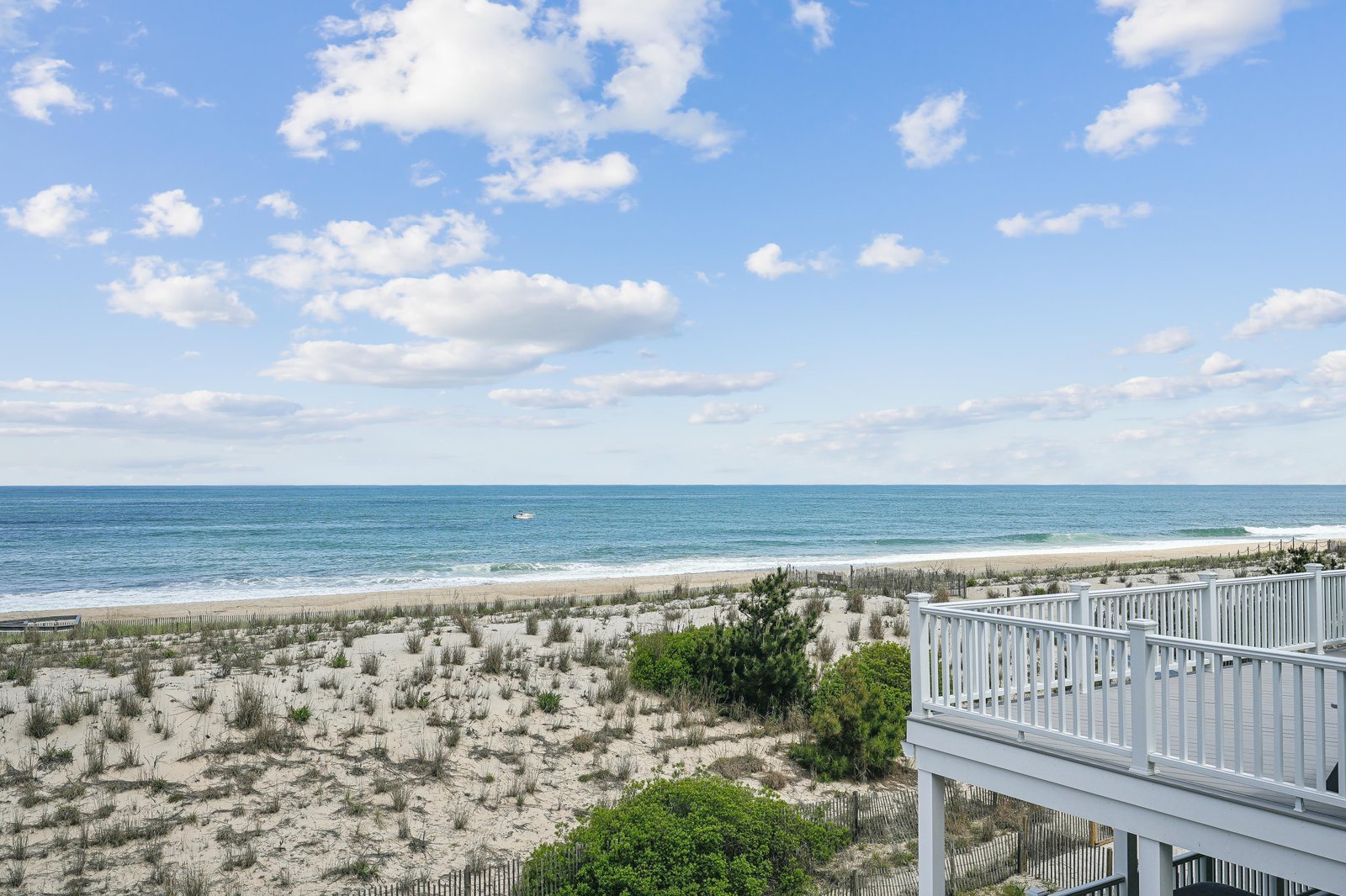 This beachfront property offers direct access to pristine sandy shores and stunning ocean views, with a private deck overlooking the dunes and sparkling water.
