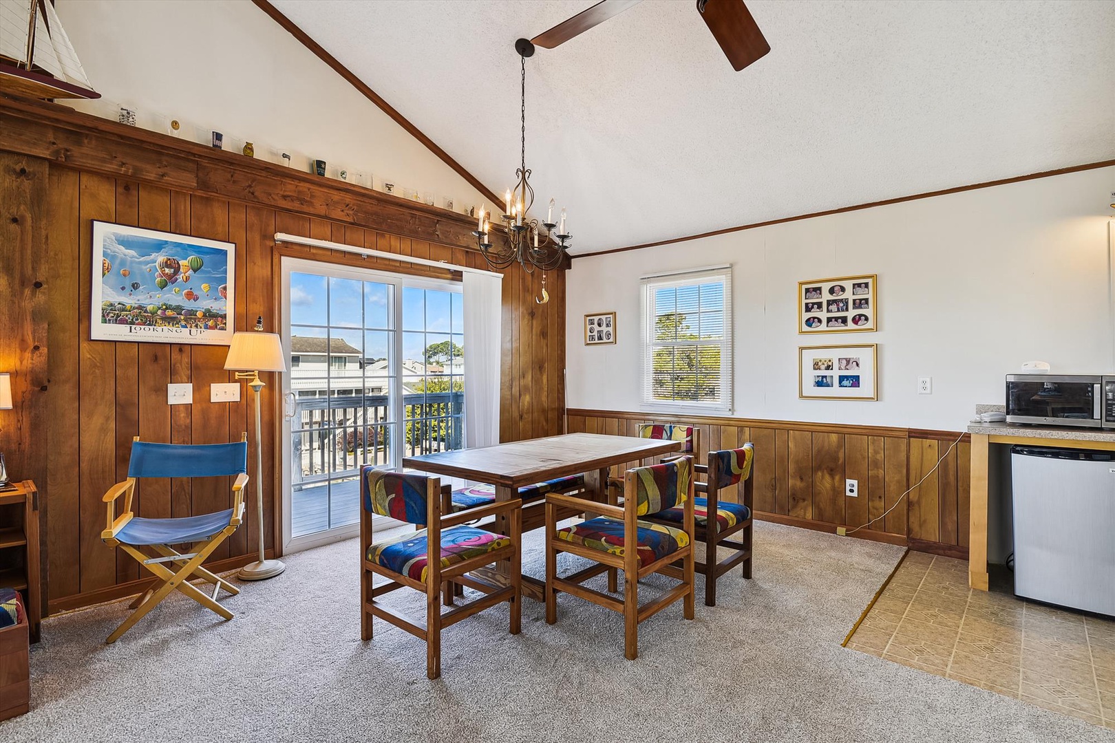 Gather around your dining table where wood paneling adds rustic charm and balcony doors invite natural light. Your cozy space blends comfort with coastal character—perfect for meals together.