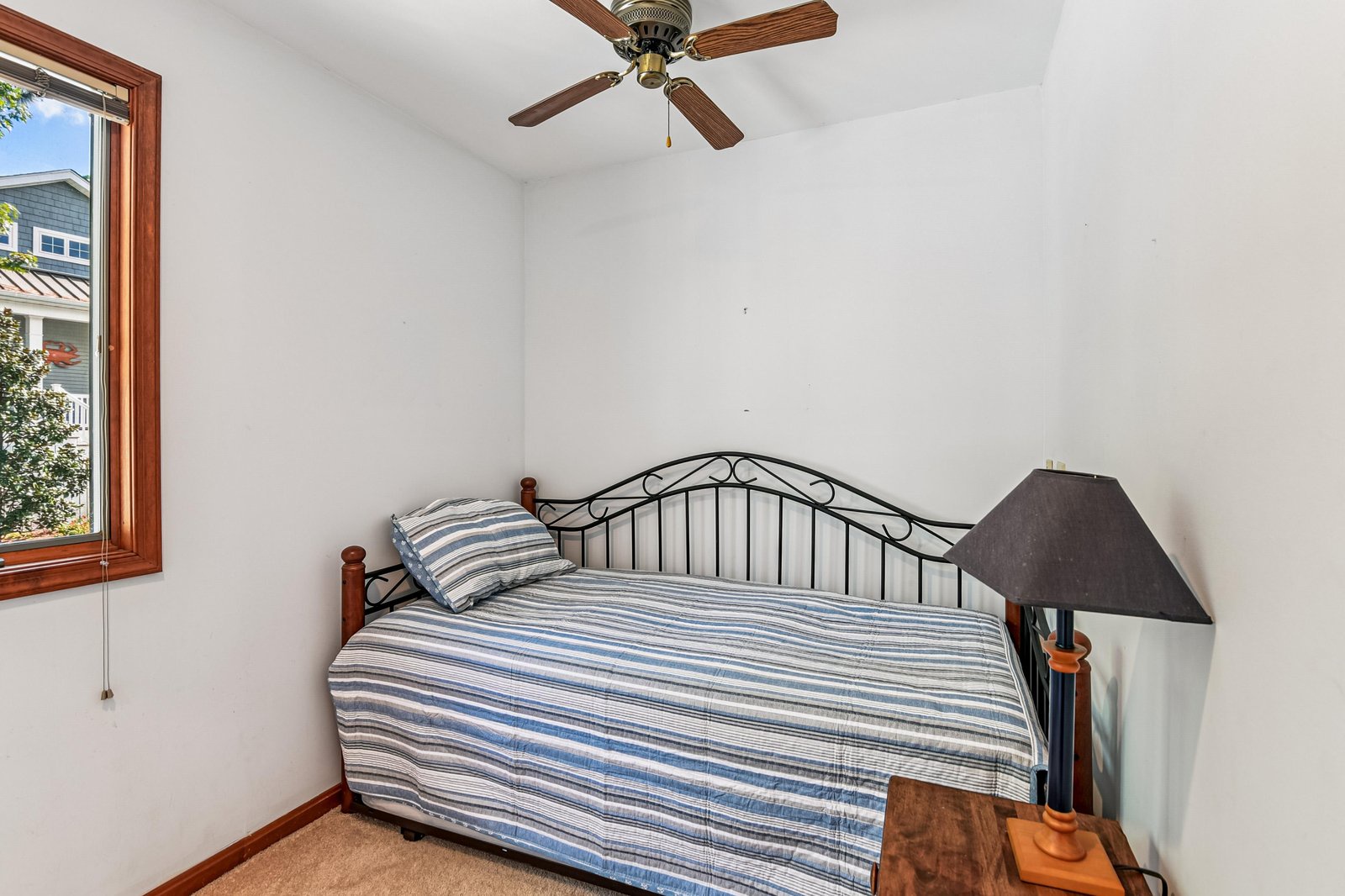 Unwind in your cozy bedroom with fresh linens and peaceful neighborhood views. A ceiling fan keeps you comfortable while you rest after a day of exploring.