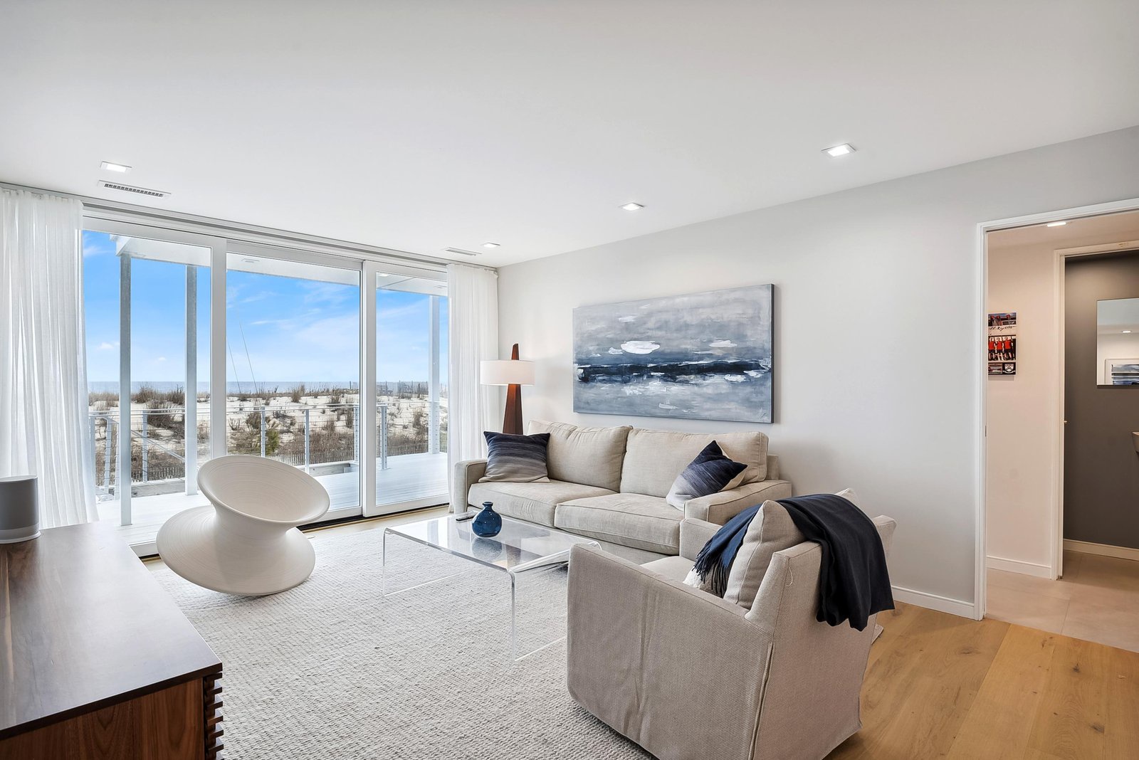 Sink into plush seating as natural light fills your elegant living space, with panoramic windows framing the surrounding neighborhood and winter landscape—your perfect retreat for relaxing after a day of exploring.