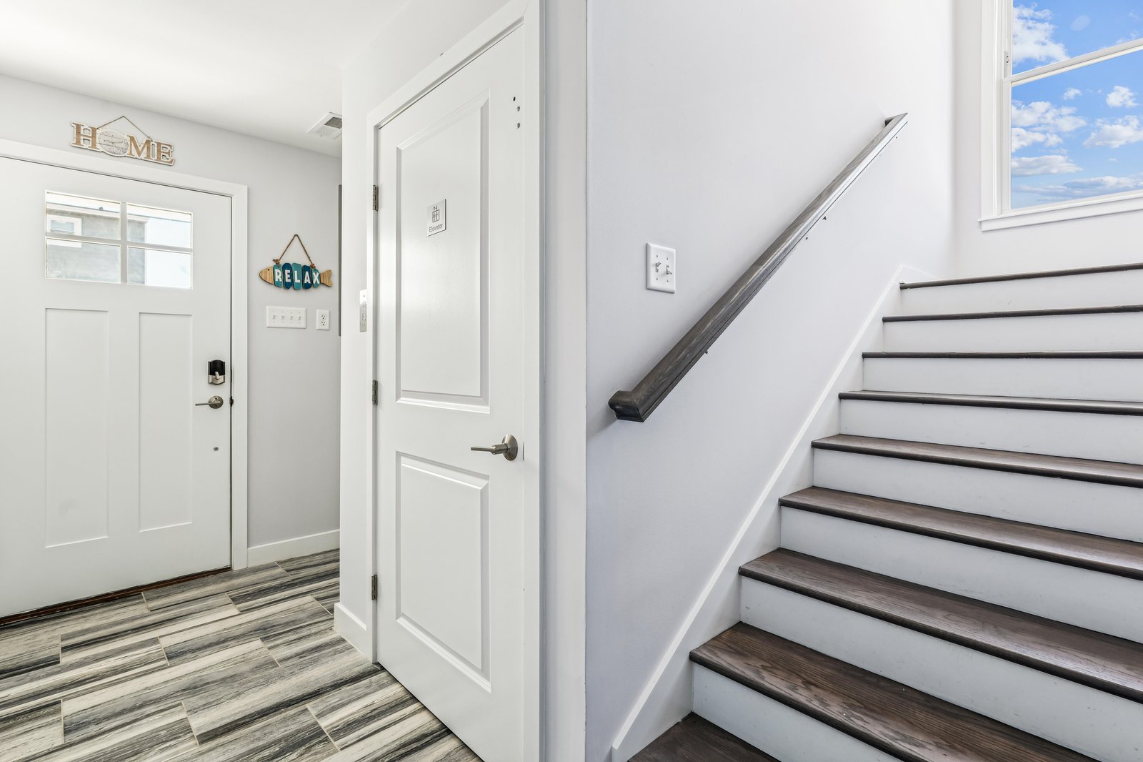 Step inside and feel right at home. The bright entryway welcomes you with a warm 'HELLO' sign, polished flooring, and soft natural light that sets the tone for your entire stay.