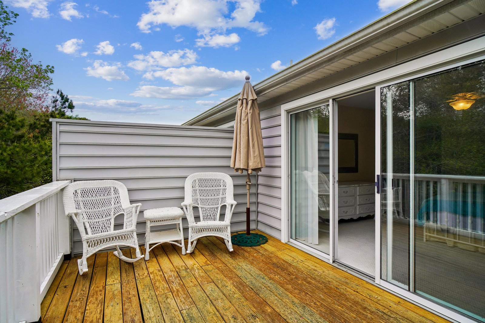 Step out onto your private deck and settle into cozy wicker chairs under the shade of an umbrella, perfect for morning coffee or evening relaxation with gentle breezes and natural light.