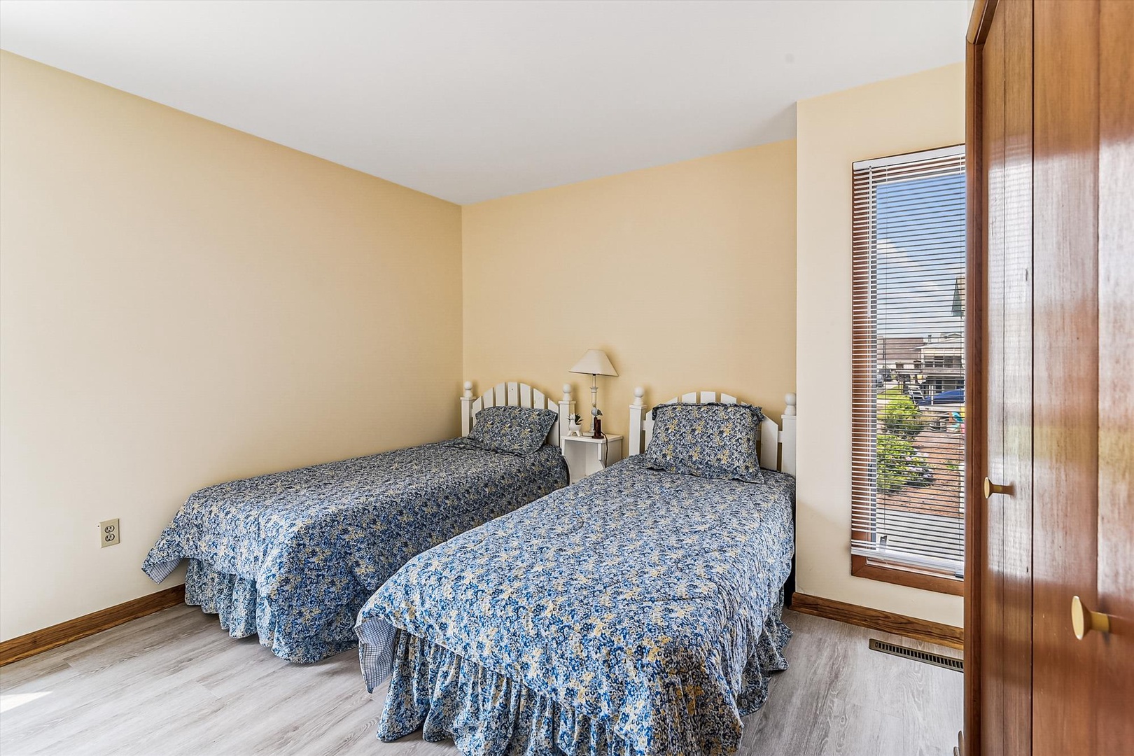 Wake up refreshed in this bright bedroom with two twin beds dressed in charming floral linens, perfect for family or friends traveling together.