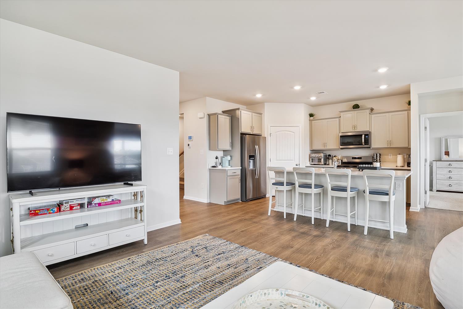 Relax in your open-concept living space where modern comfort meets functionality, featuring a spacious kitchen and cozy seating area perfect for unwinding.