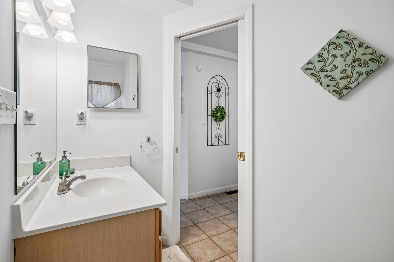 Bright, spotless bathroom with ample counter space and thoughtful decor touches ensures your morning routine feels effortless and refreshing.