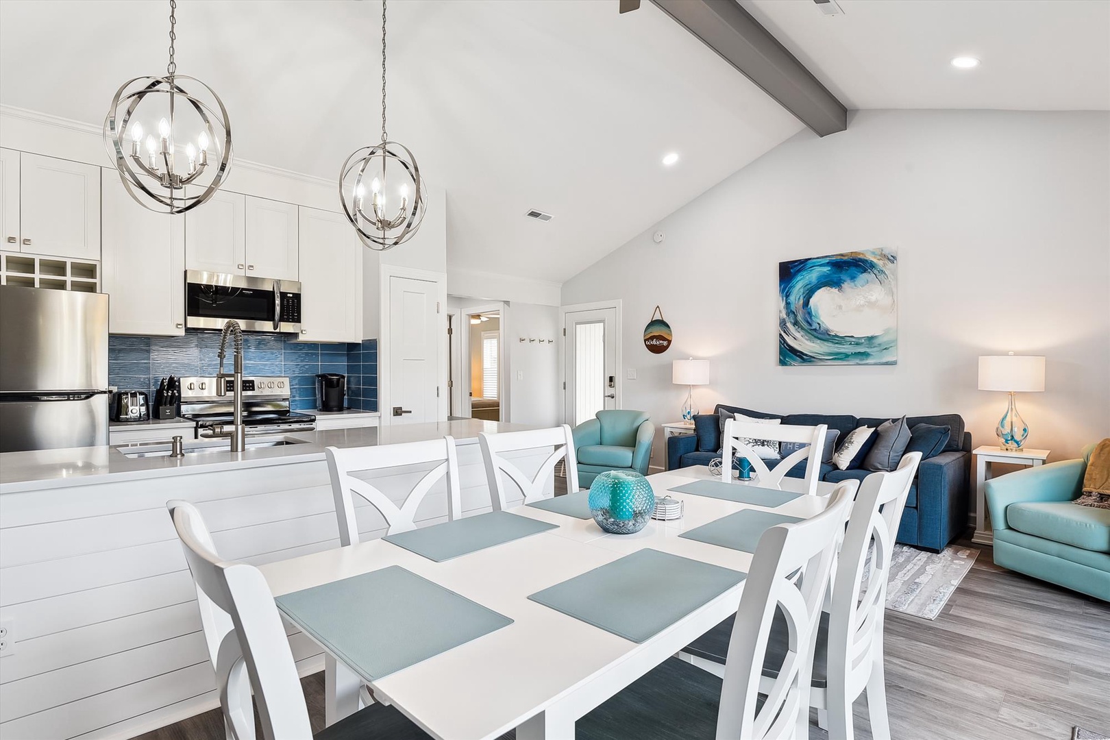 Relax in your open-concept living space with coastal-inspired décor, modern kitchen, and vaulted ceilings that create an airy, inviting atmosphere perfect for gathering with loved ones.