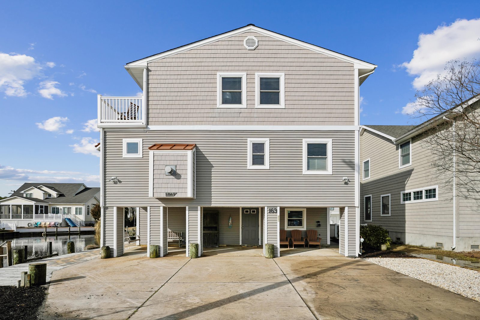 Elevated coastal property with private balcony, ground-level parking, and easy access to waterfront living in a peaceful neighborhood.