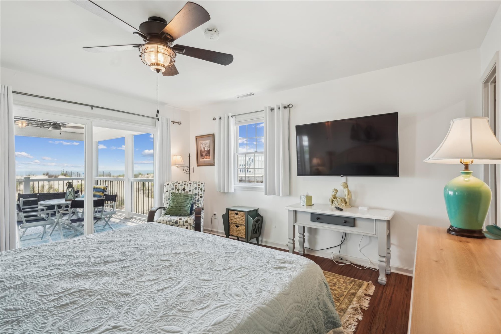 Your bright, airy bedroom invites relaxation with plush bedding, soothing coastal tones, and direct access to a private balcony overlooking serene beach views.