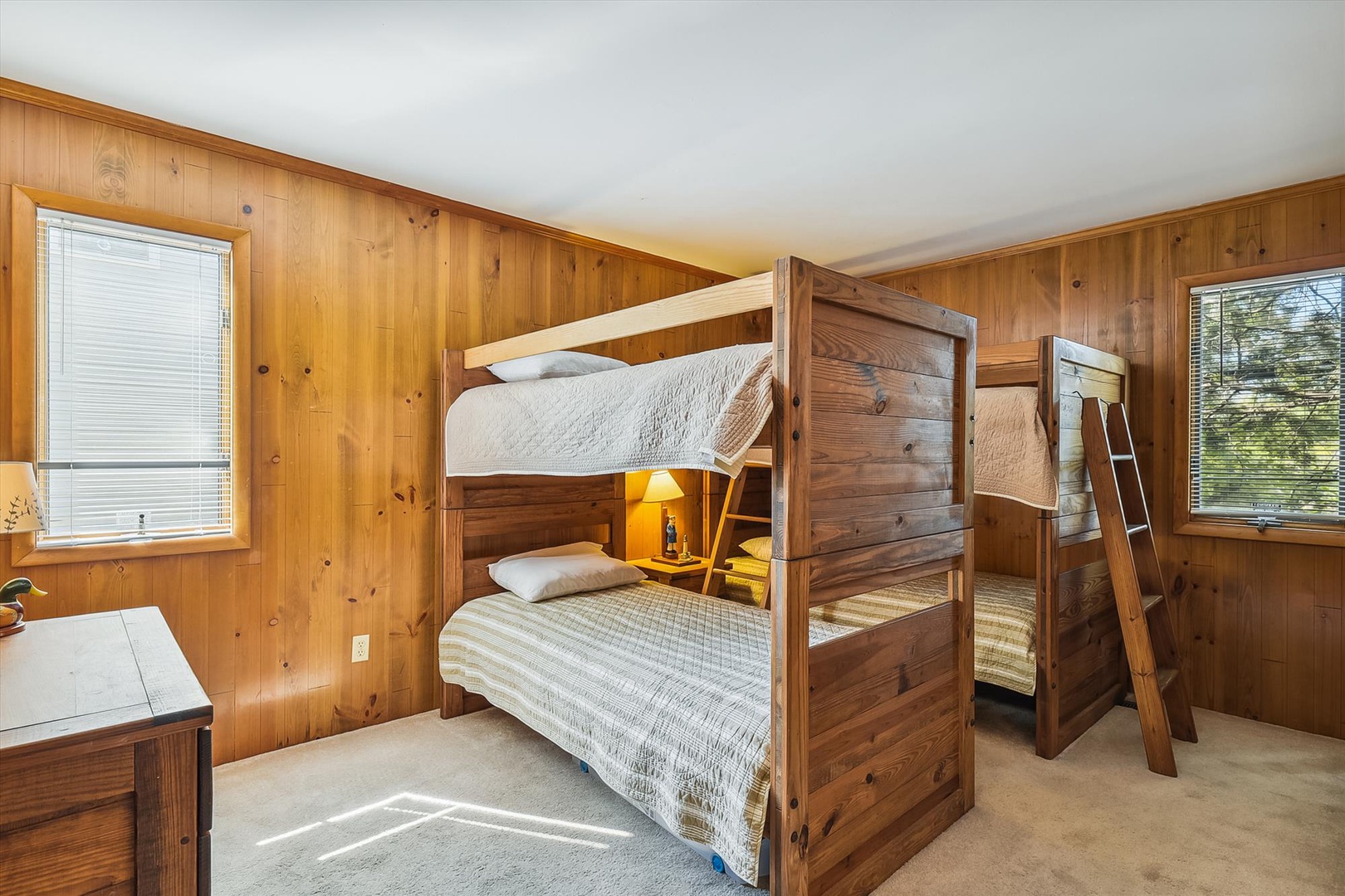 Settle into this cozy bunk room with warm wood paneling and natural light—perfect for kids or groups to share stories before drifting off to sleep.