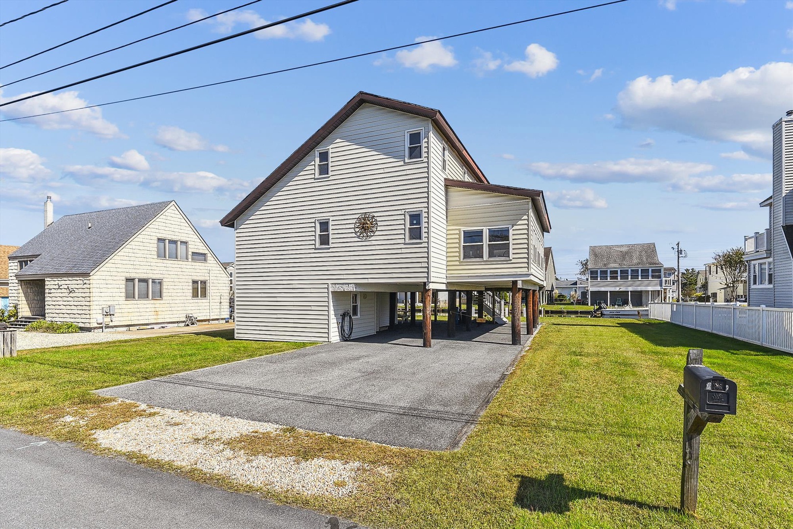 Coastal property featuring elevated construction with covered parking and easy beach access in a residential neighborhood.