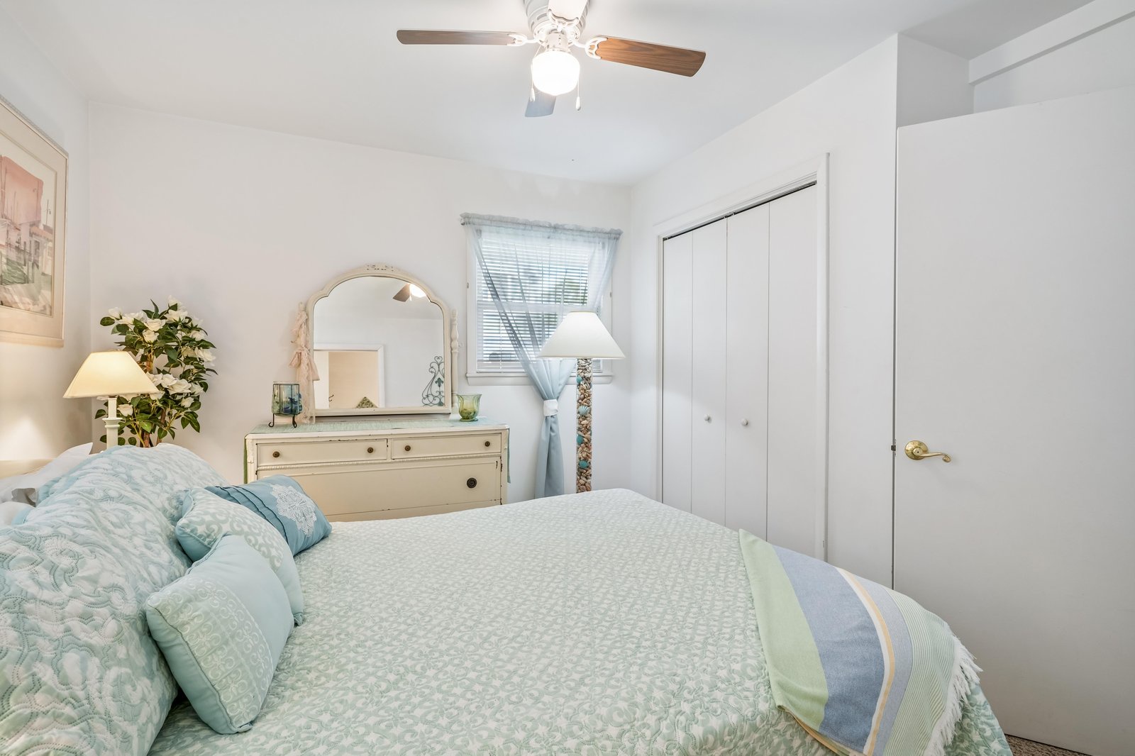 Relax in this serene bedroom with its coastal-inspired palette of soft blues and greens. Natural light filters through your windows, while a ceiling fan keeps you cool and comfortable during your stay.