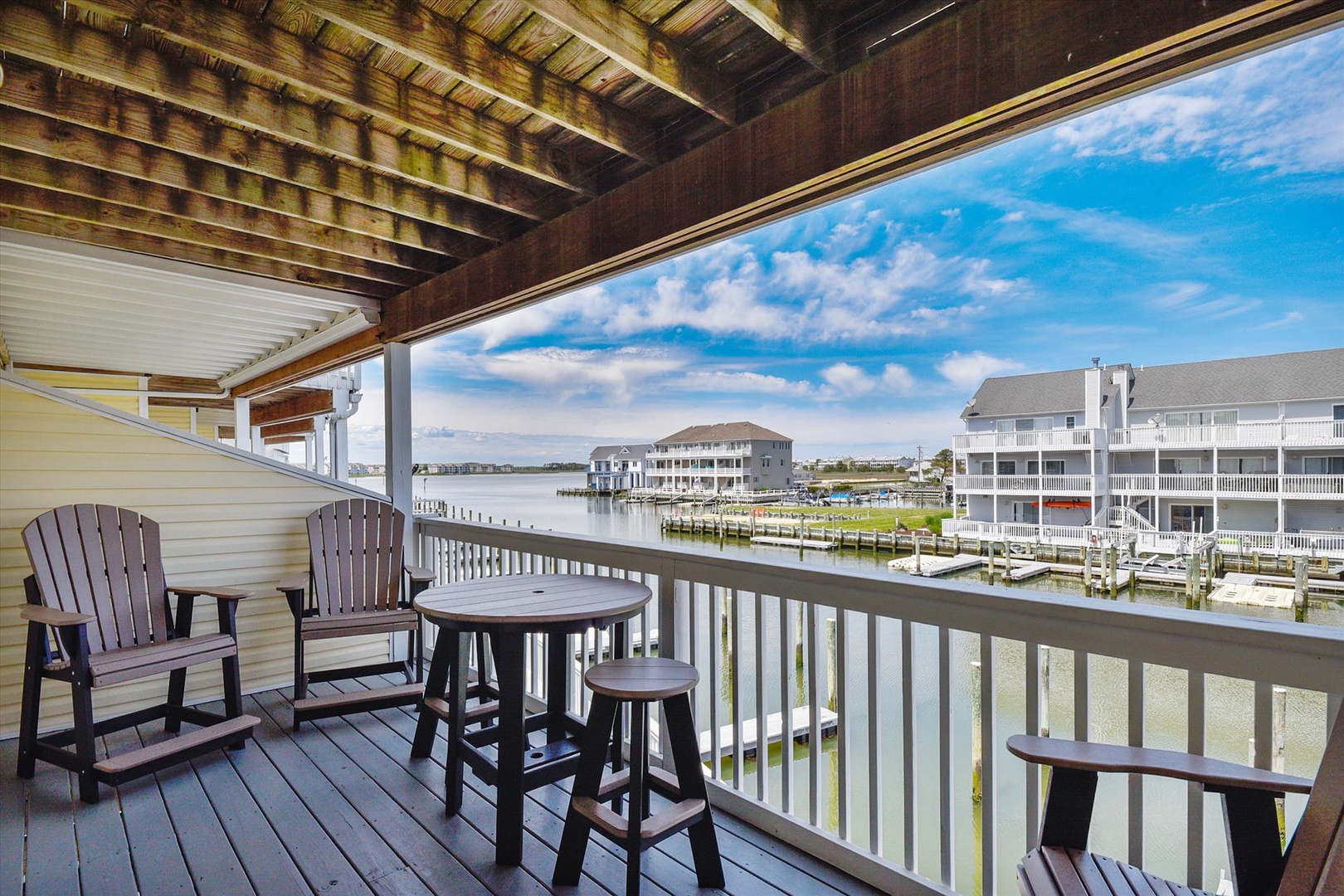 Perch on your private waterfront balcony and soak in sweeping views of the marina, boats gently bobbing along the docks, and serene water stretching beneath a bright blue sky.