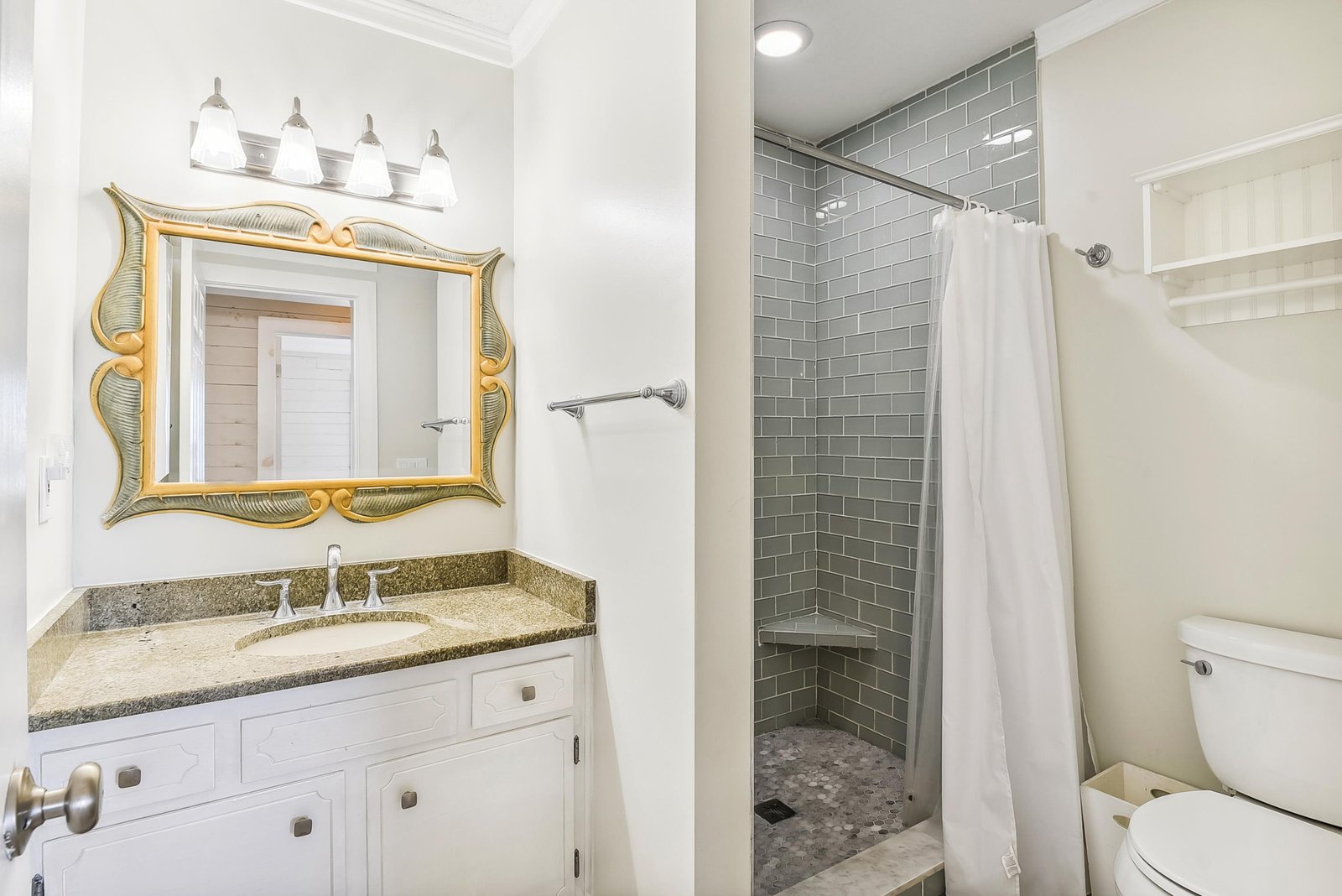 Your private bathroom features a stylish subway-tiled shower and granite vanity. Fresh towels are always waiting, and the bright lighting makes mornings feel effortless.