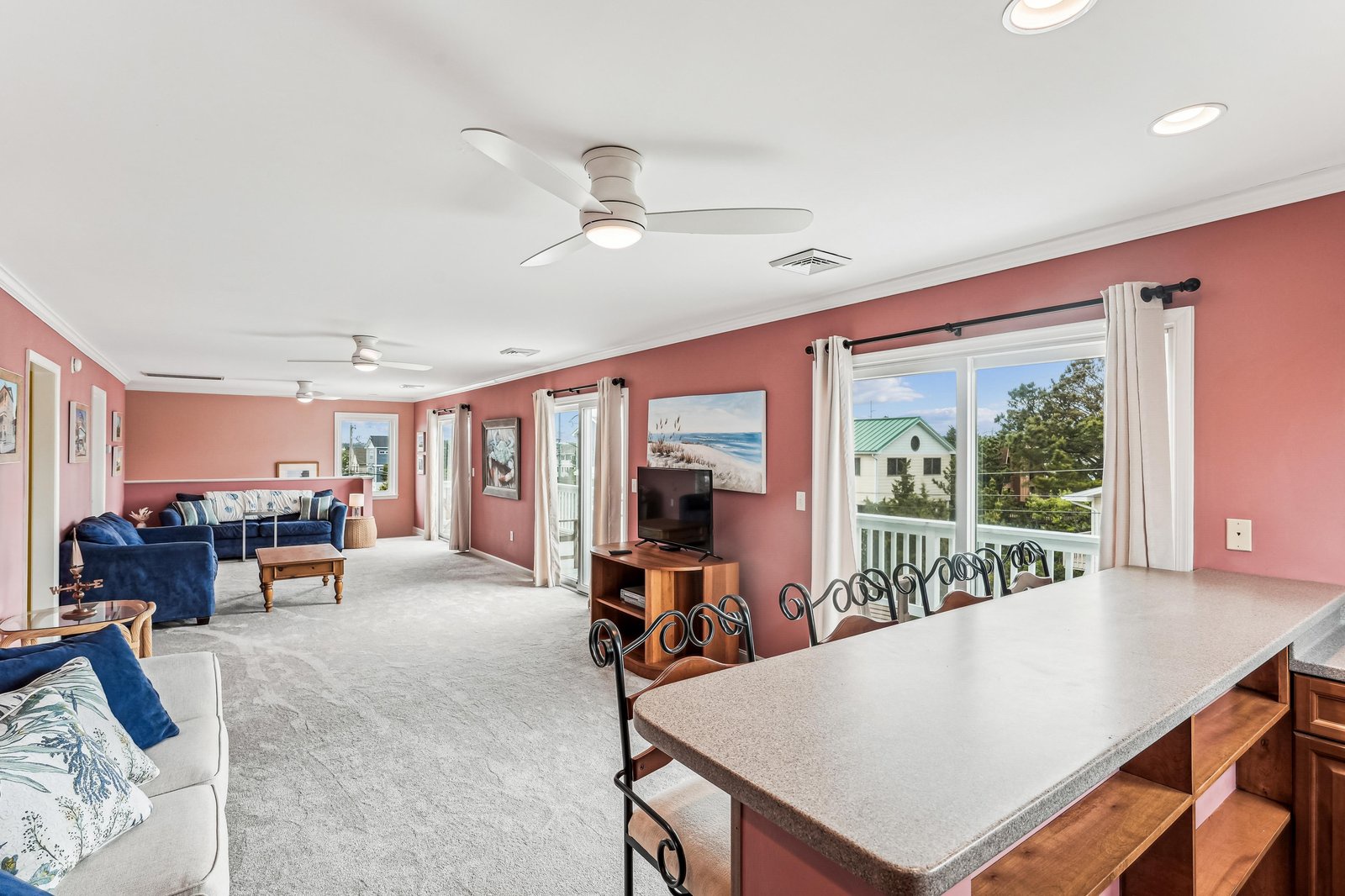 Bright, open living space with ceiling fans, plenty of seating, and windows framing your private view—perfect for relaxing after a day exploring.