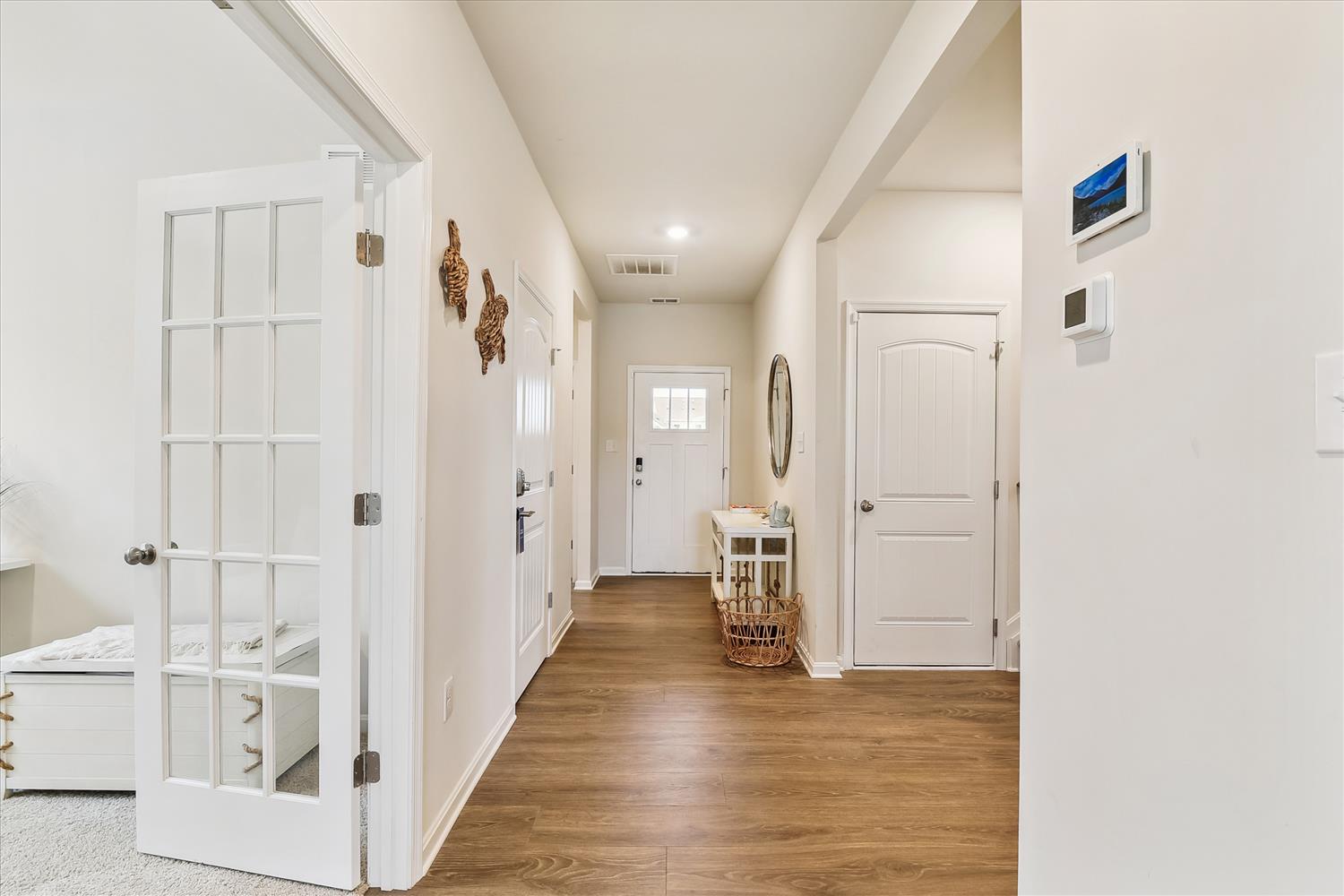 Step into your bright, welcoming hallway with gleaming hardwood floors and charming coastal touches that instantly make you feel at home.