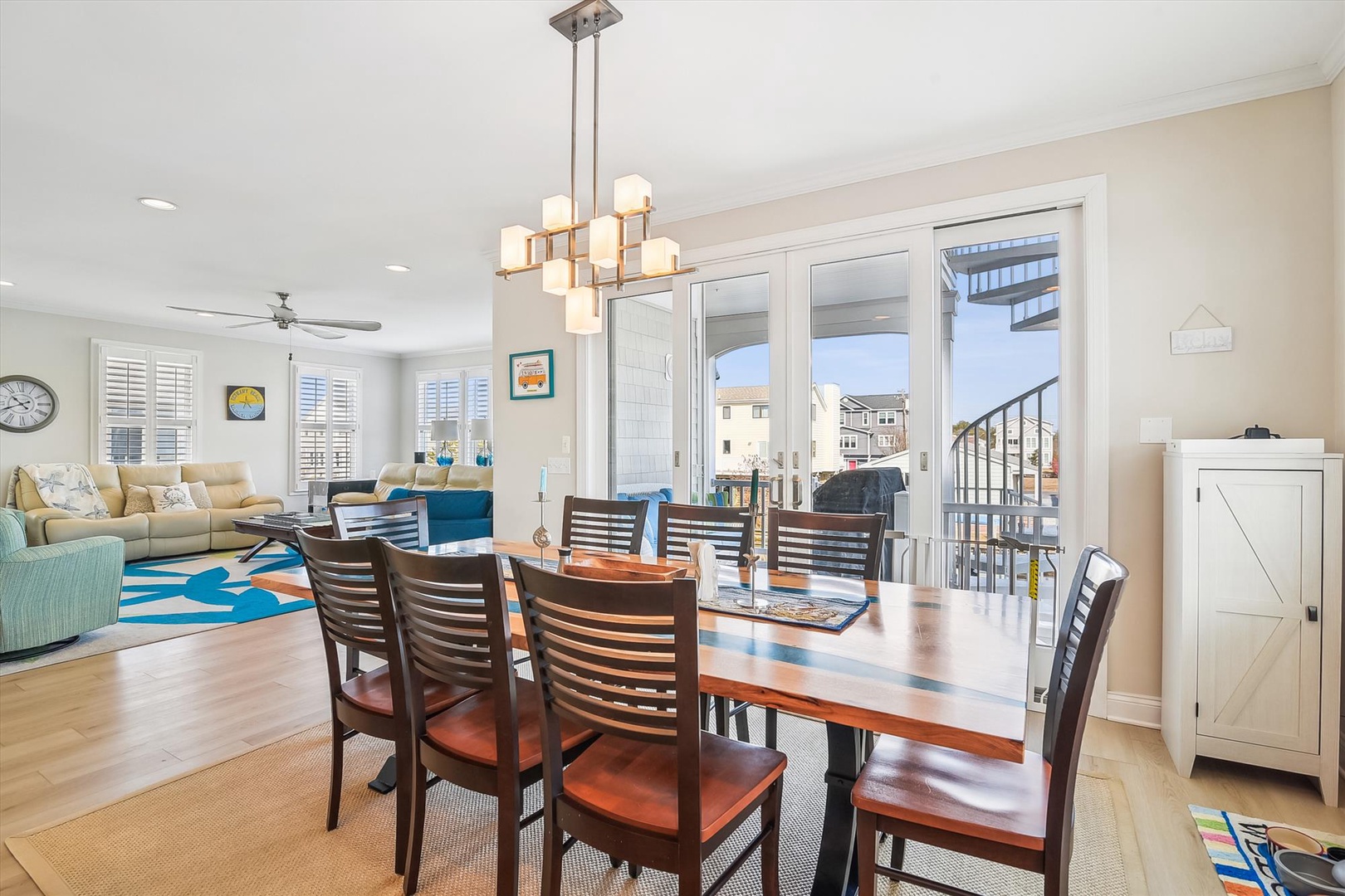 Gather around this beautiful dining table where your group can share meals and stories, with natural light streaming through the French doors and the open layout connecting you to the cozy living room.