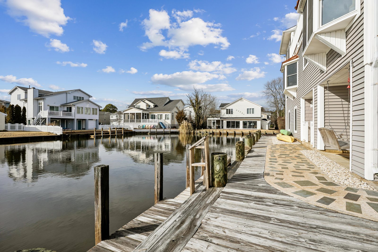This waterfront property features a private dock with direct water access, nestled in a peaceful canal community with charming homes lining the shores.