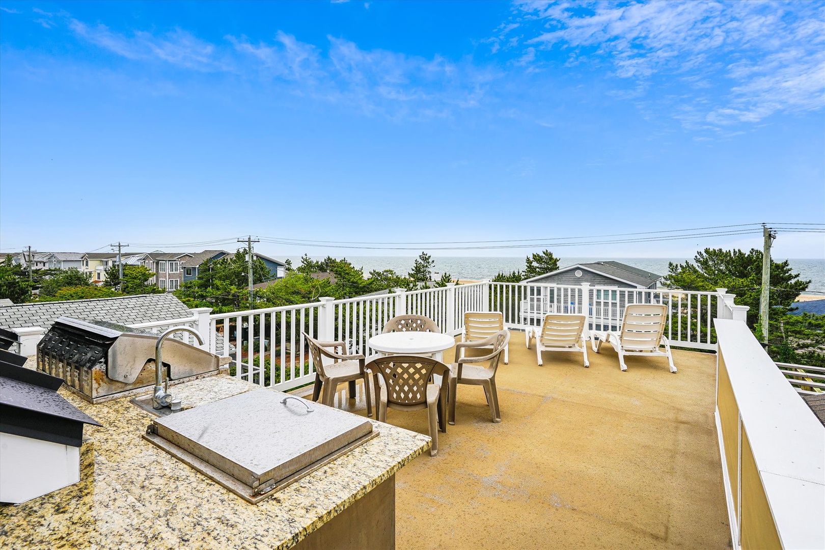 A spacious rooftop deck with ocean views, outdoor seating, and a built-in grilling area—perfect for your sunset cookouts and morning coffee under open skies.