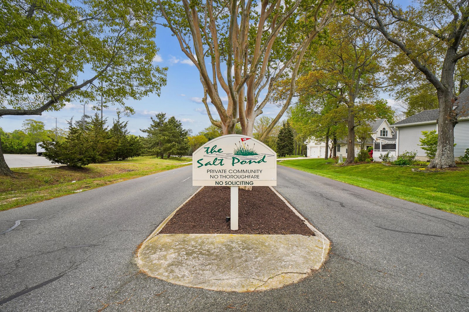 The Salt Pond community entrance, a private residential neighborhood surrounded by mature trees and well-maintained homes.