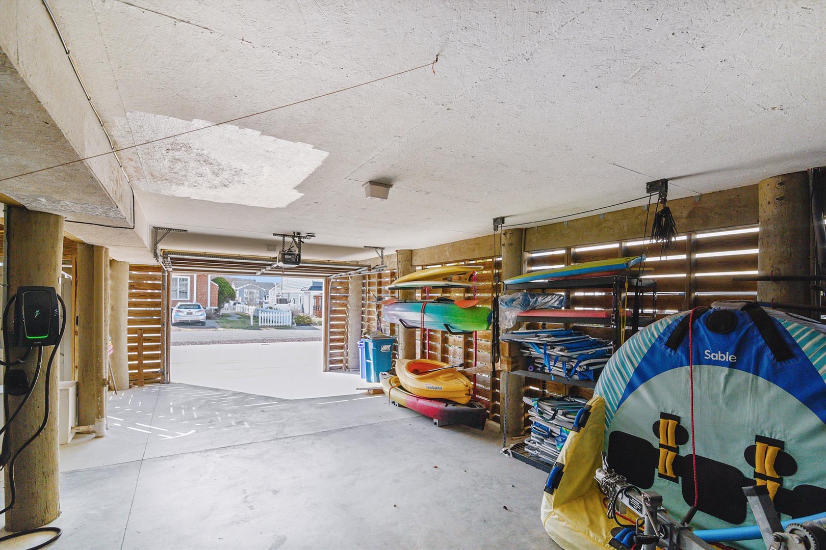 Spacious garage stocked with kayaks, paddleboards, and beach gear ready for your next water adventure. Everything you need for a fun-filled day on the waves is here.
