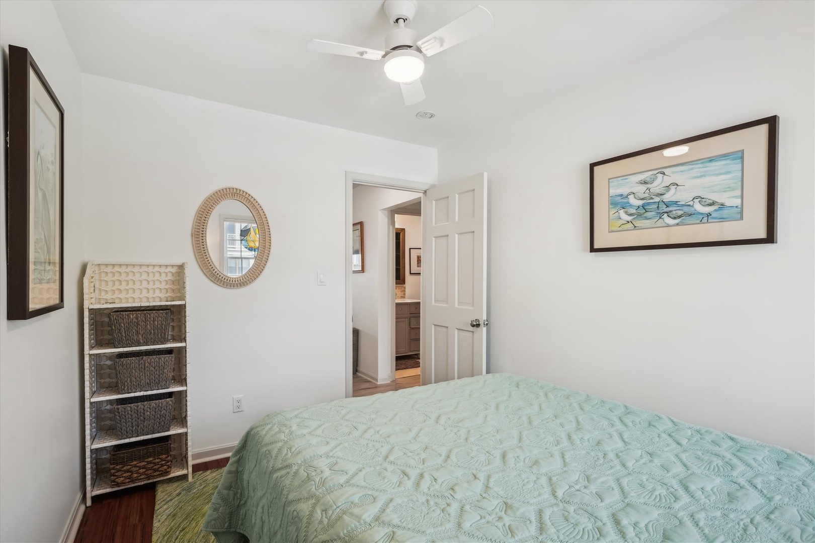 Relax in your coastal-themed bedroom with soft linens, beach-inspired art, and a ceiling fan to keep you comfortable. Coastal decor and thoughtful storage create a serene retreat for your getaway.
