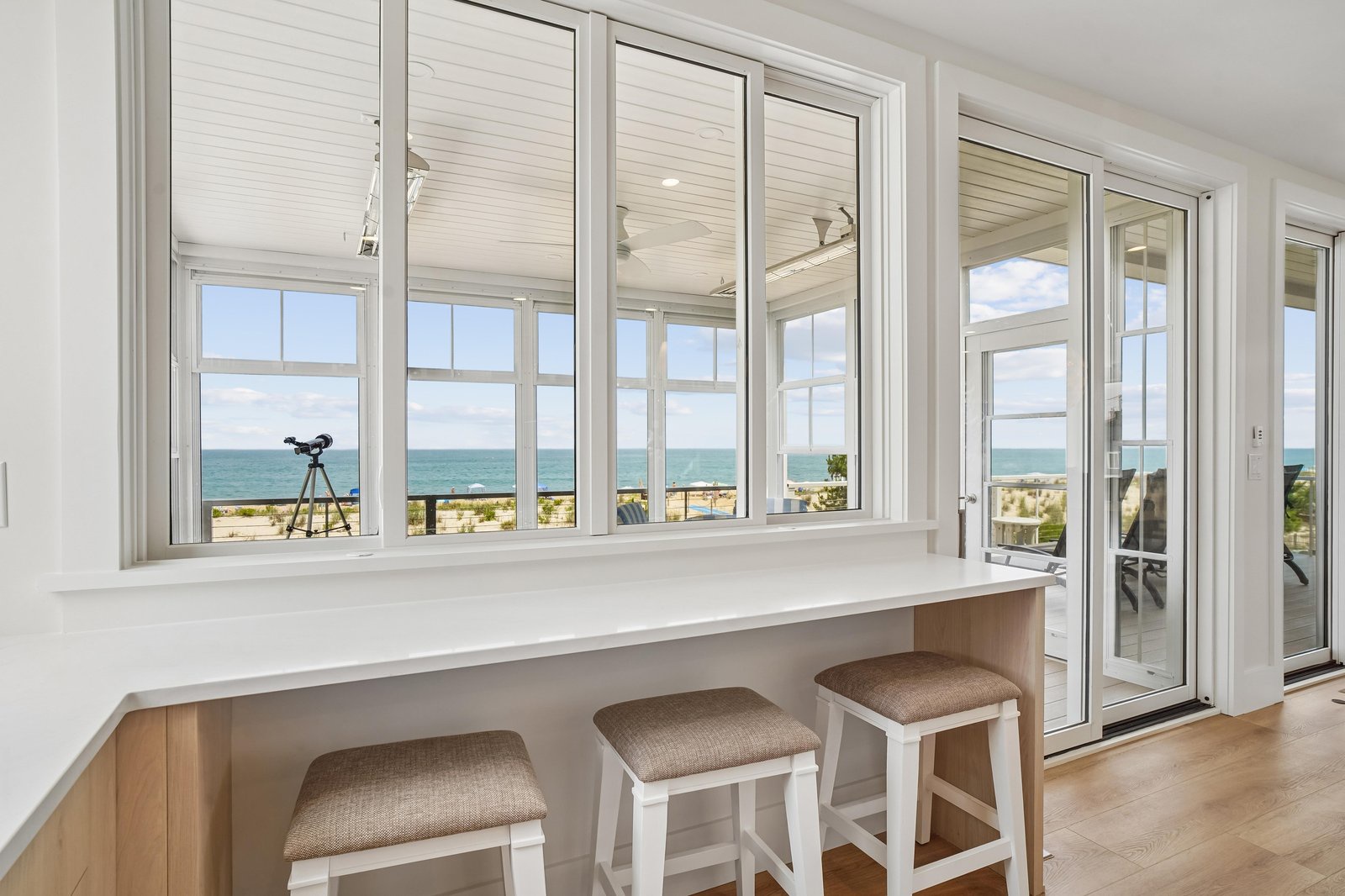 Settle into this bright coastal nook with stunning ocean views through expansive windows, perfect for your morning coffee or watching the waves roll in.