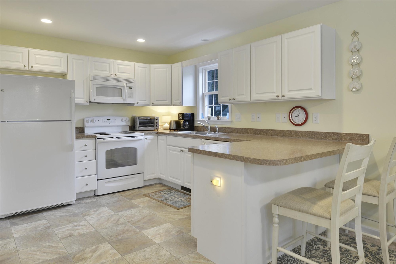 Your fully equipped kitchen features bright white cabinetry, modern appliances, and a breakfast bar where you can enjoy morning coffee or plan your day's adventures.