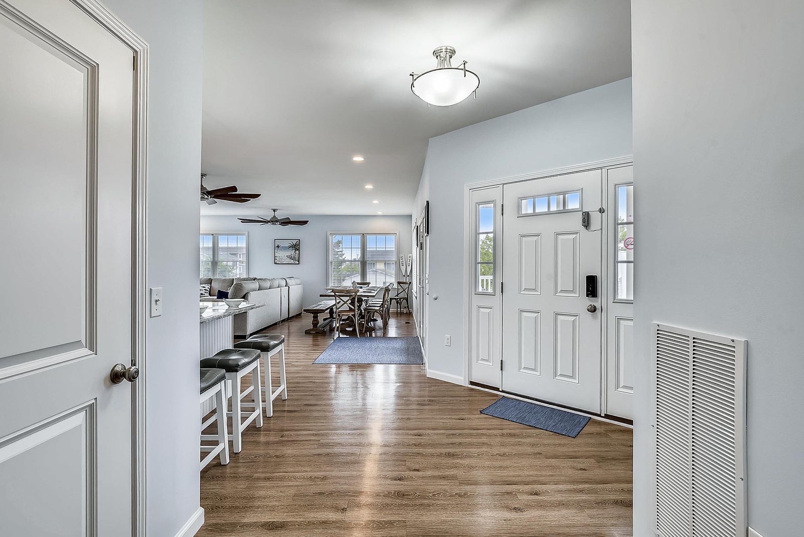 Step inside this bright, welcoming entryway, where warm wood floors and high ceilings set a relaxed tone. Your vacation starts the moment you arrive in this open, airy space.