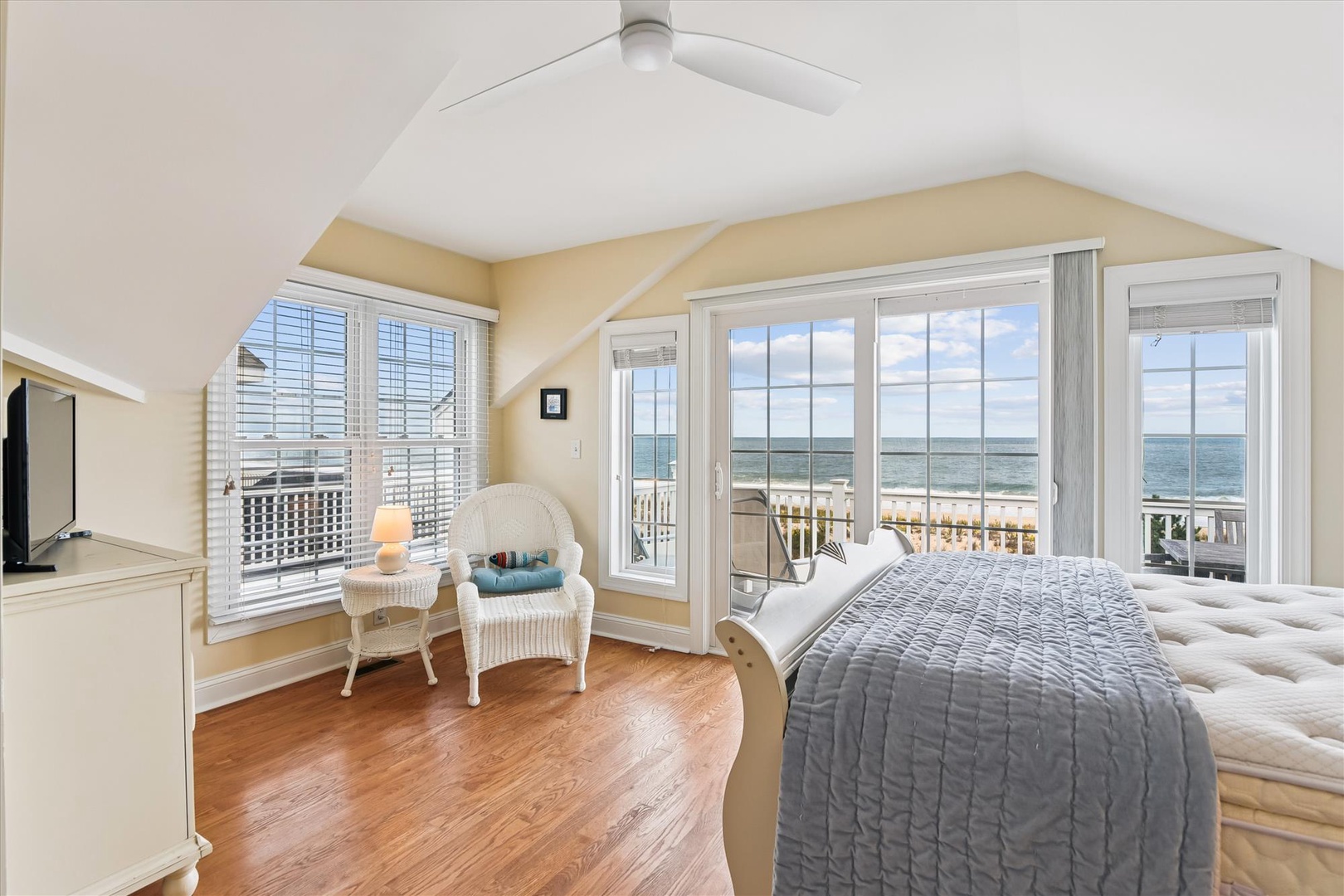 Wake up to stunning ocean views from your sunlit bedroom, where vaulted ceilings and private balcony access invite serene mornings and restful nights by the sea.