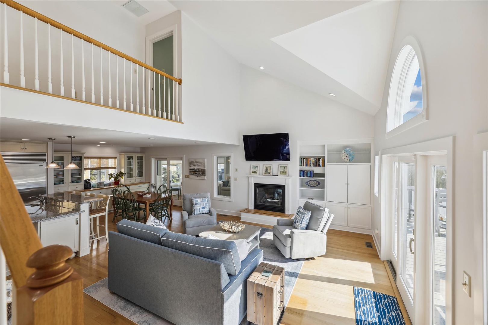 Sunlight streams through soaring cathedral ceilings into your open-concept living space, where cozy seating by the fireplace meets a chef's kitchen—perfect for gathering and unwinding.