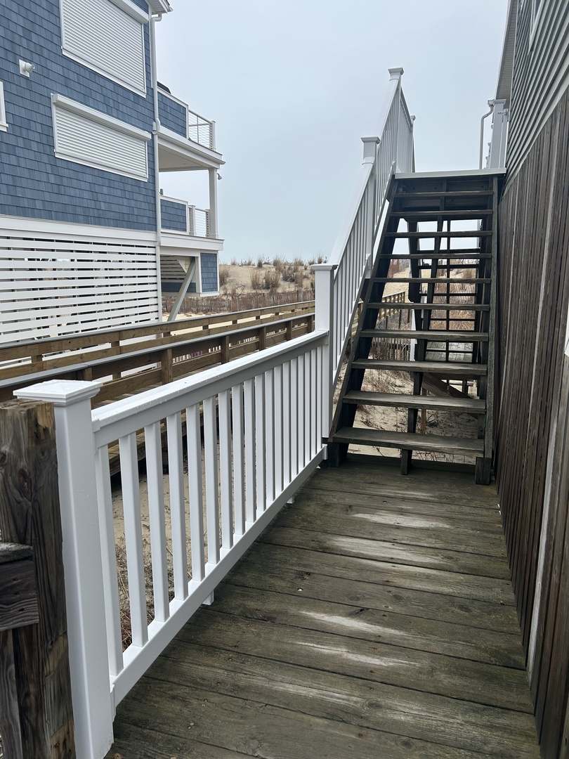 Step onto your private covered balcony with rustic wooden beams and white railings, creating a charming outdoor retreat.