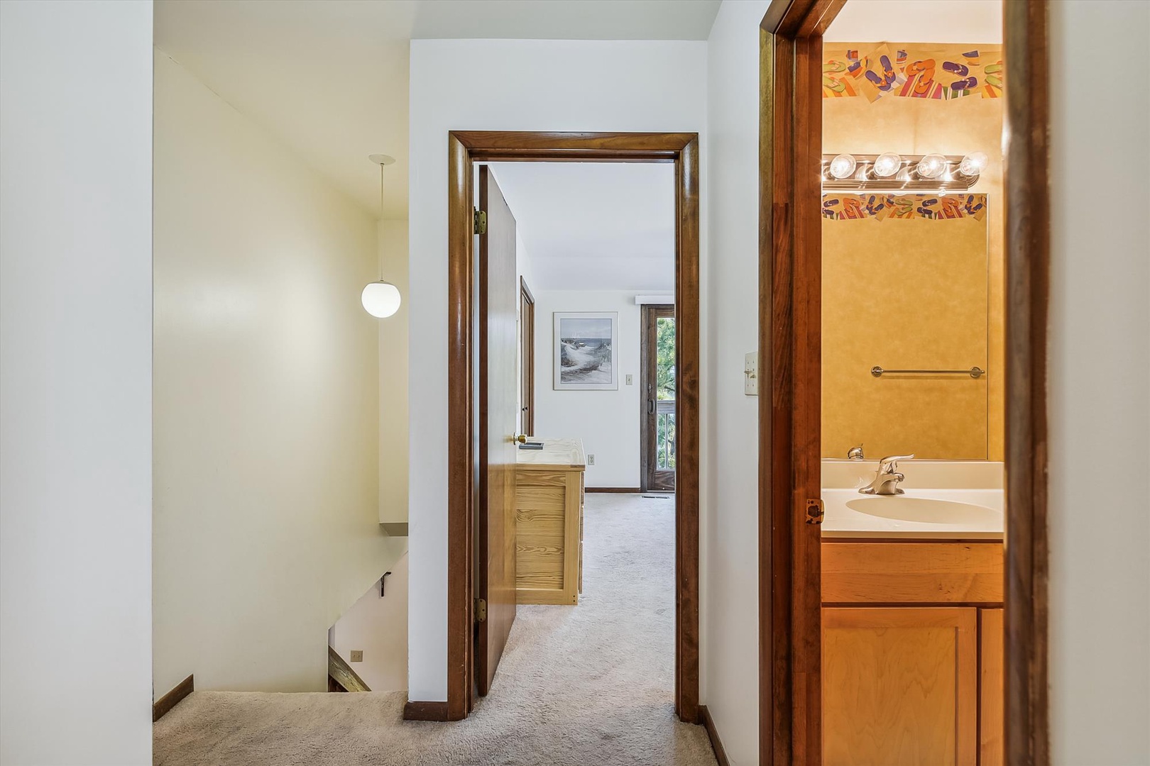 A light-filled hallway connects your private spaces—sink into plush carpeting as warm wood tones guide you from restful bedroom to refreshing bathroom. Thoughtfully designed for easy, comfortable living.