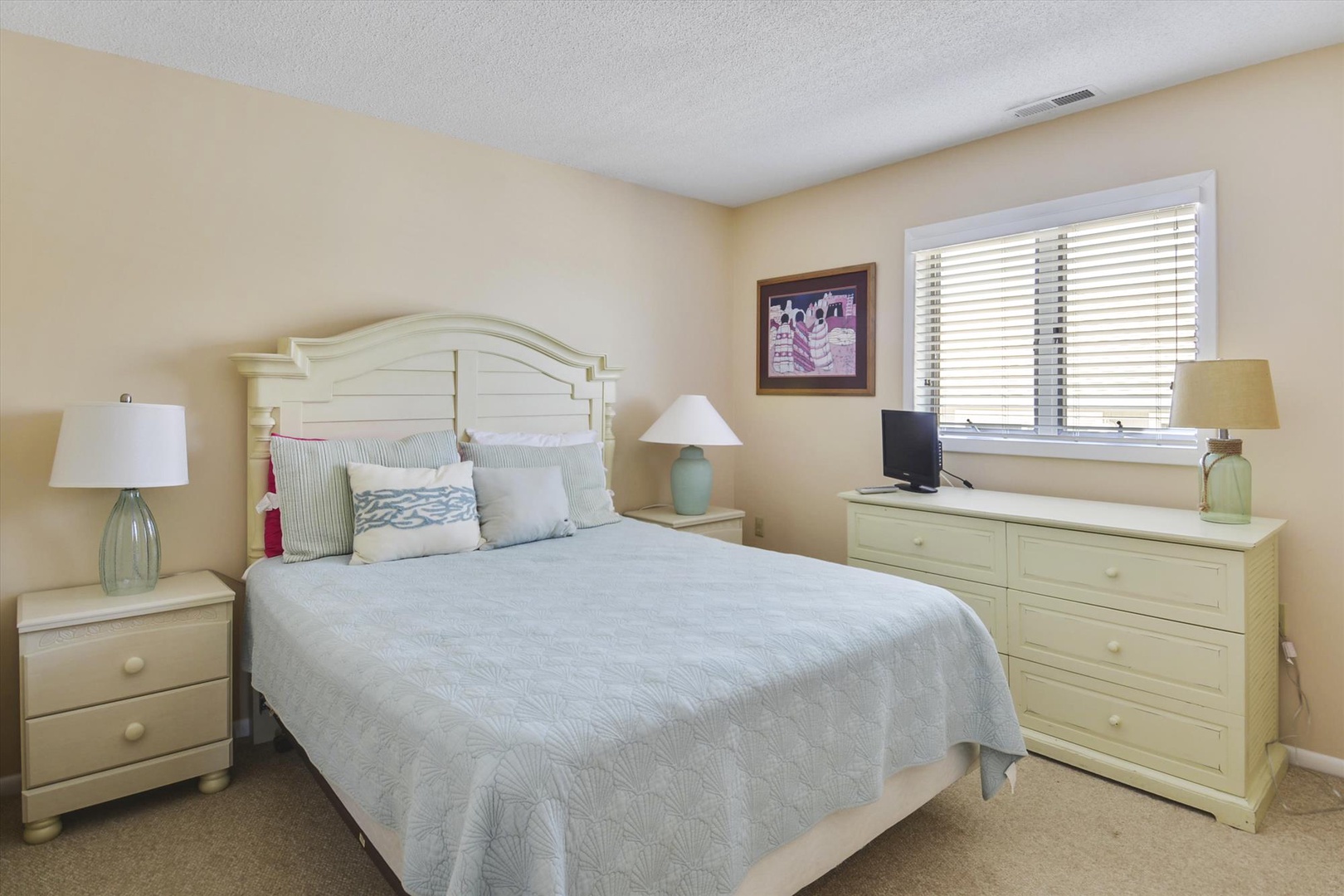 Drift into restful sleep in your serene bedroom with coastal charm, featuring soft linens, elegant furnishings, and gentle natural light filtering through the window.