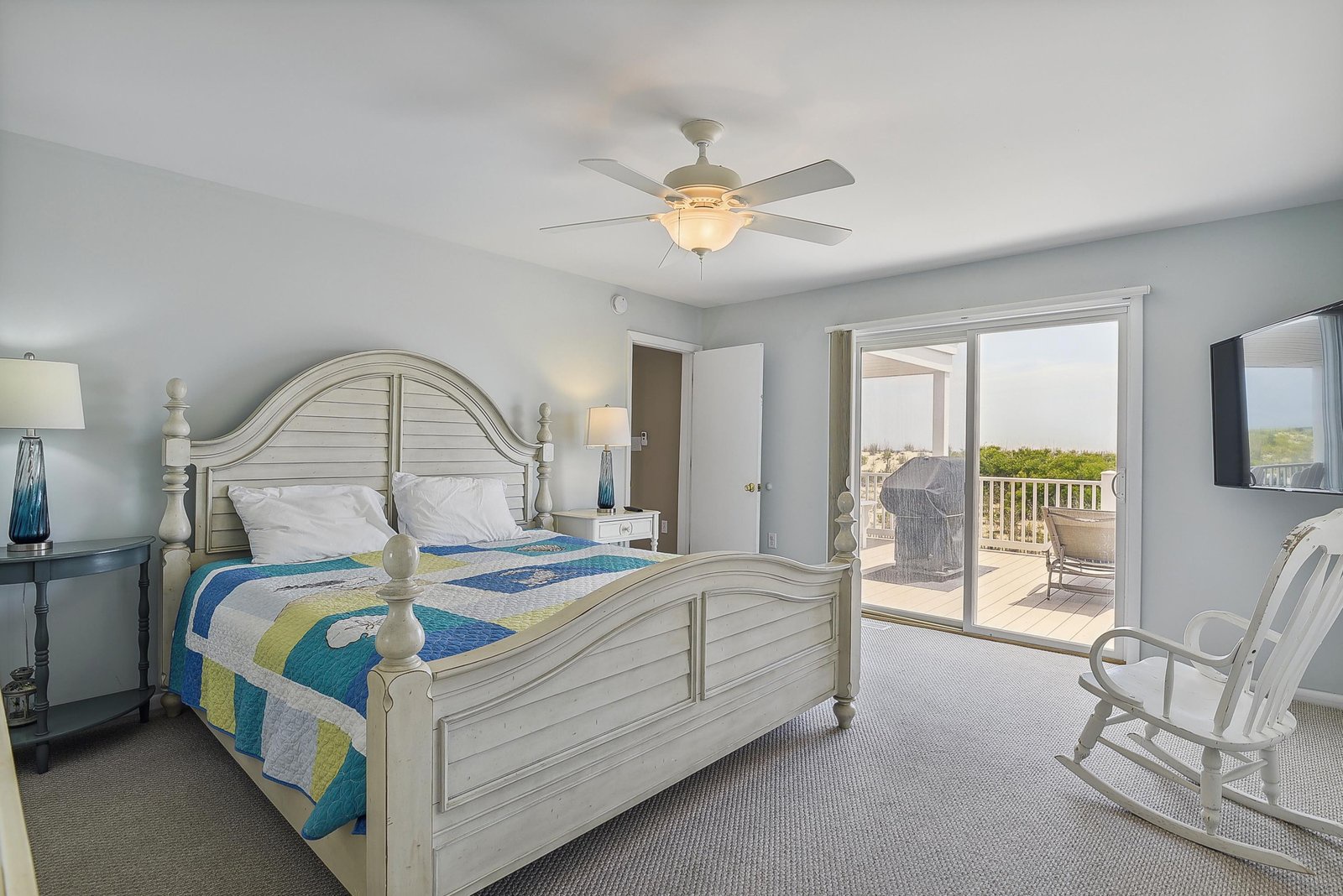 Unwind in your serene bedroom with coastal charm—slide open the doors to your private balcony and feel the breeze, or simply rock in the chair and soak in the tranquility.