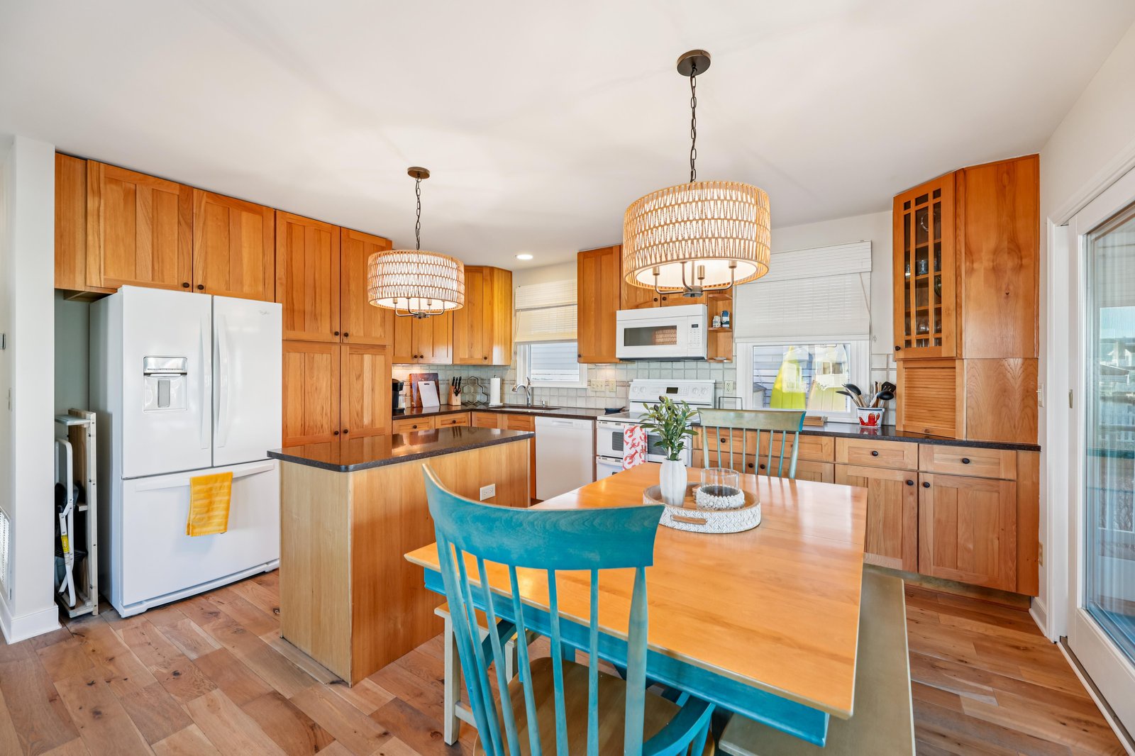 Gather around this inviting kitchen where warm wood tones and thoughtful design create the perfect space for your morning coffee or evening meal prep. You'll love the ample counter space and natural light streaming in.