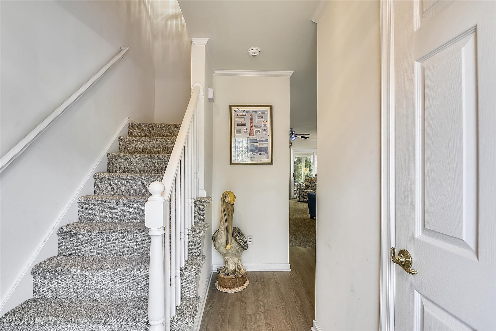 Bright and airy entryway with hardwood floors and soft carpeted stairs leading to your private upstairs retreat. The welcoming interior offers a seamless flow into spacious living areas.