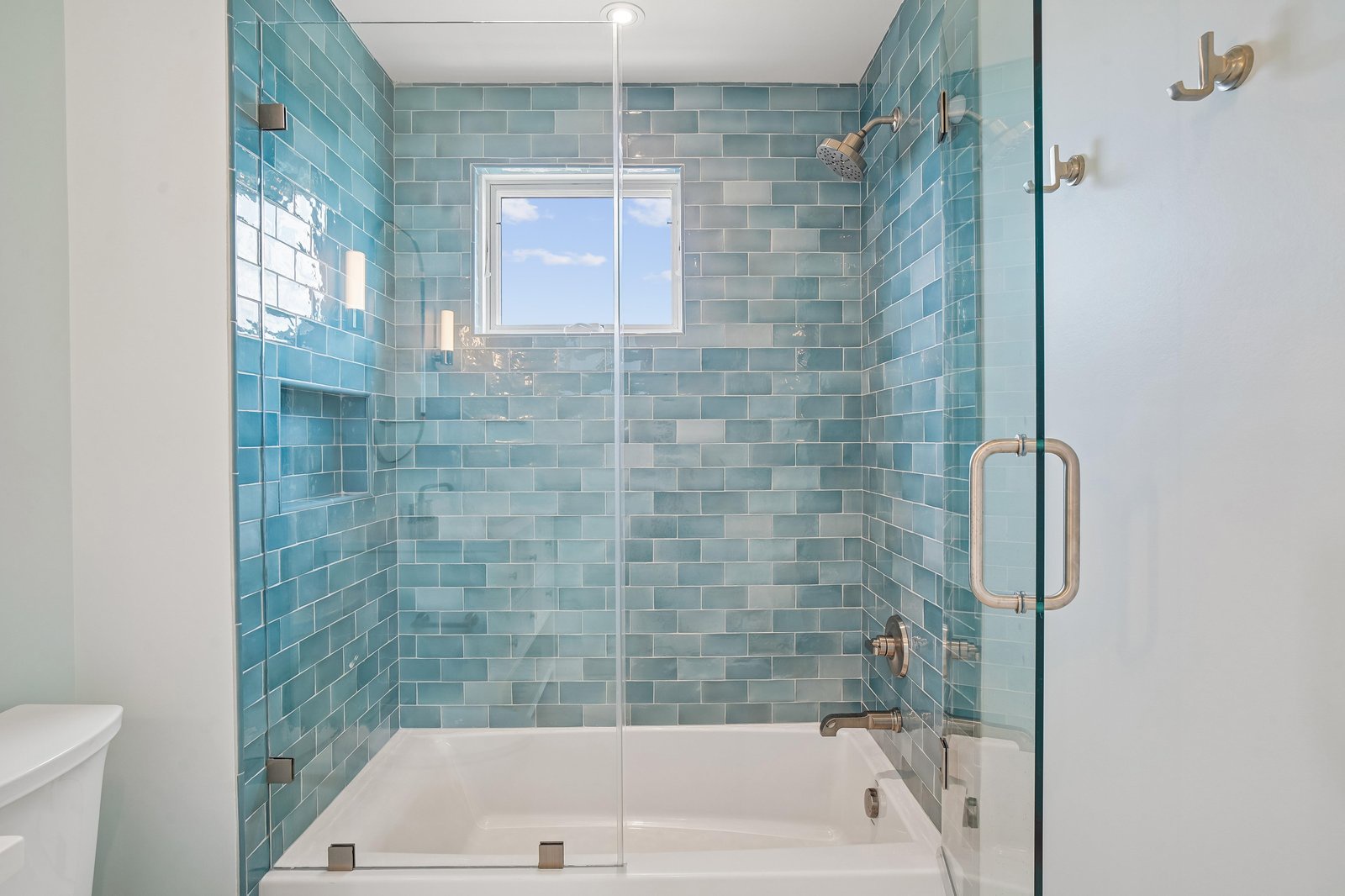 Step into your spa-inspired bathroom featuring stunning aqua subway tiles that evoke calm ocean vibes. Dual rainfall and handheld showers plus a deep soaking tub make this your personal wellness retreat.