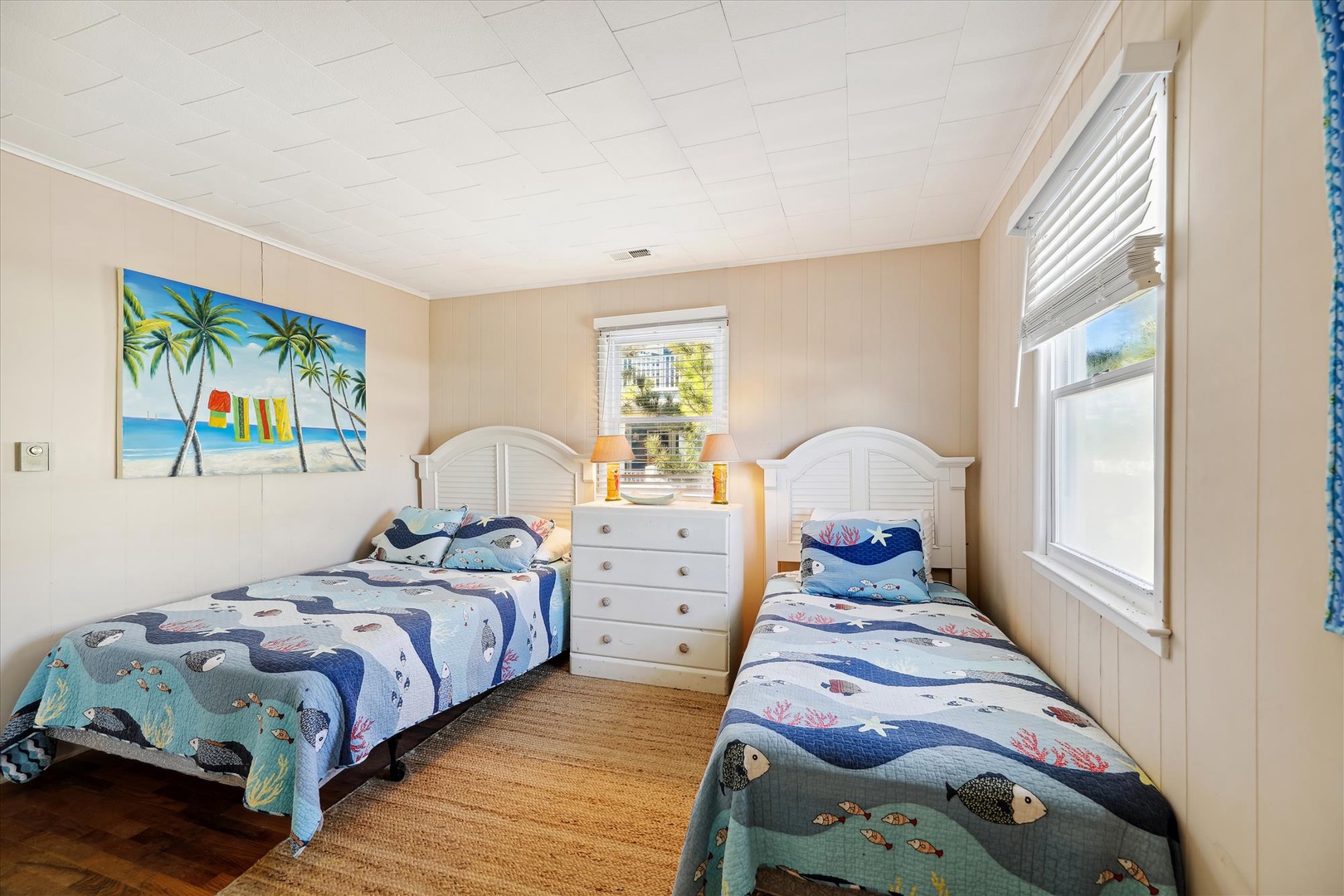 Drift off to dreams of ocean adventures in this cheerful coastal bedroom. Two cozy twin beds with playful sea creature bedding await your family, while beachy artwork sets a relaxed vacation vibe.