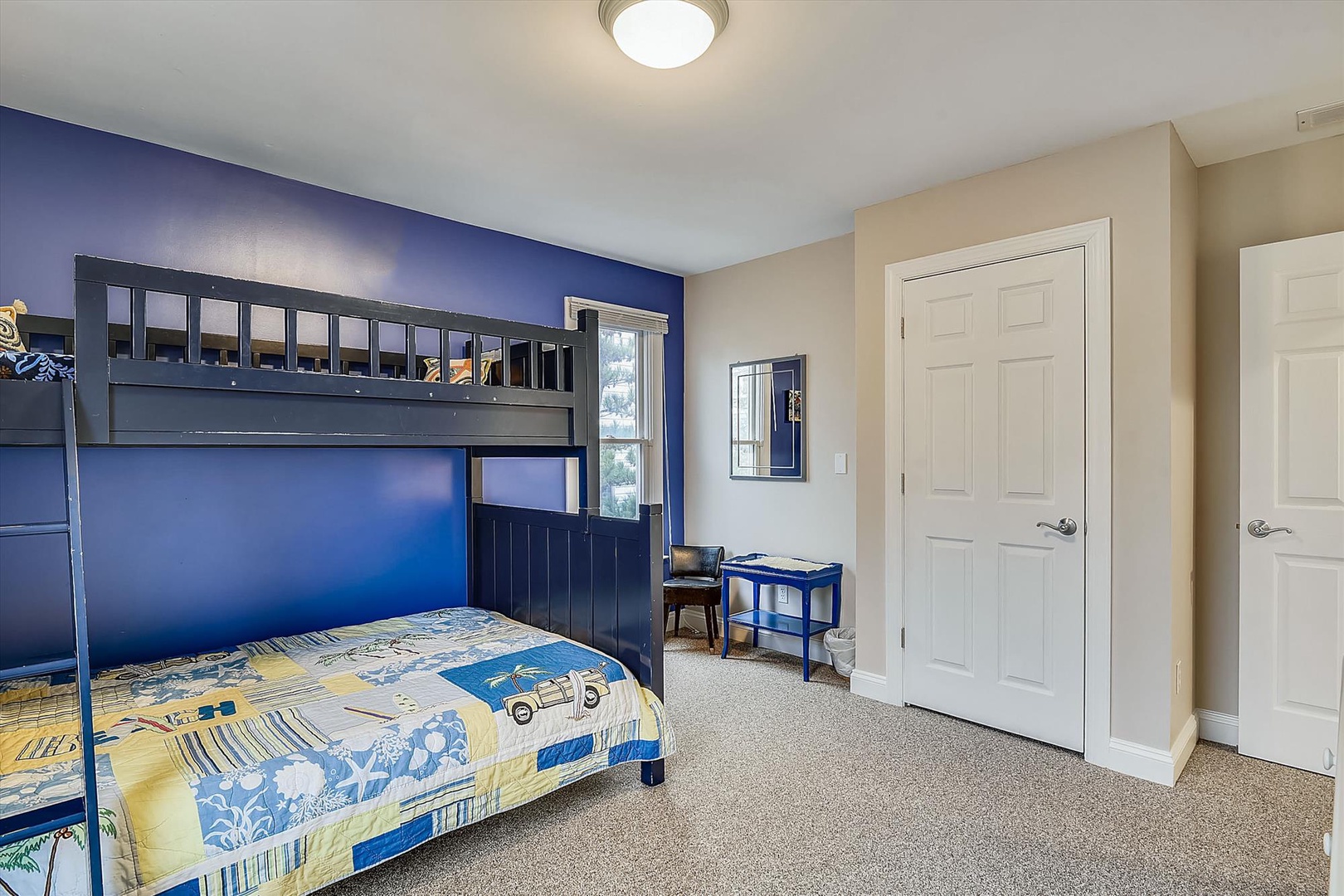 Step into a cheerful bedroom where your kids will love the nautical-blue bunk beds and bright, sunny decor—perfectly designed for cozy family moments.