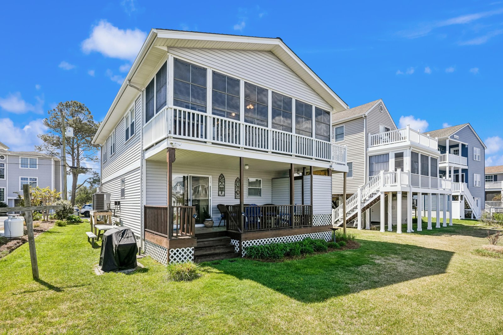 This waterfront property features a spacious sun porch and dual outdoor decks overlooking a well-maintained lawn. The coastal neighborhood setting provides convenient water access and a peaceful residential atmosphere.