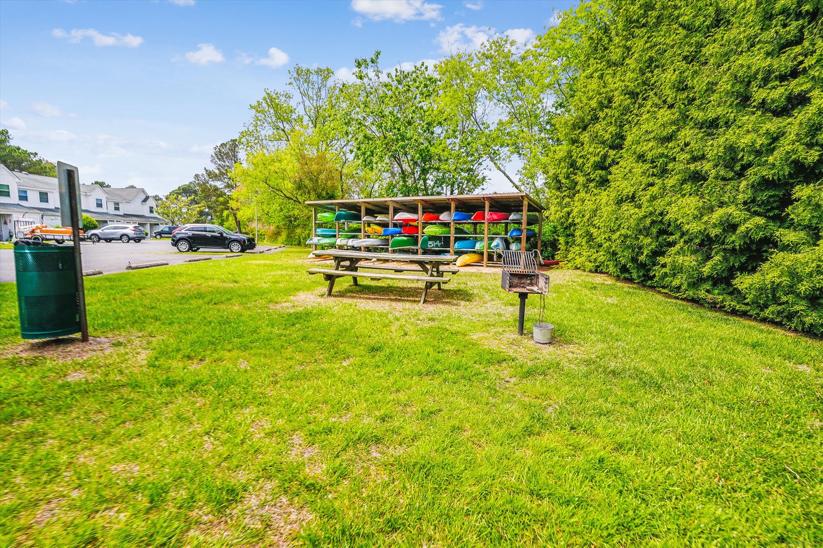 Grab your favorite kayak from the colorful collection and enjoy a peaceful picnic at the outdoor tables surrounded by lush greenery.