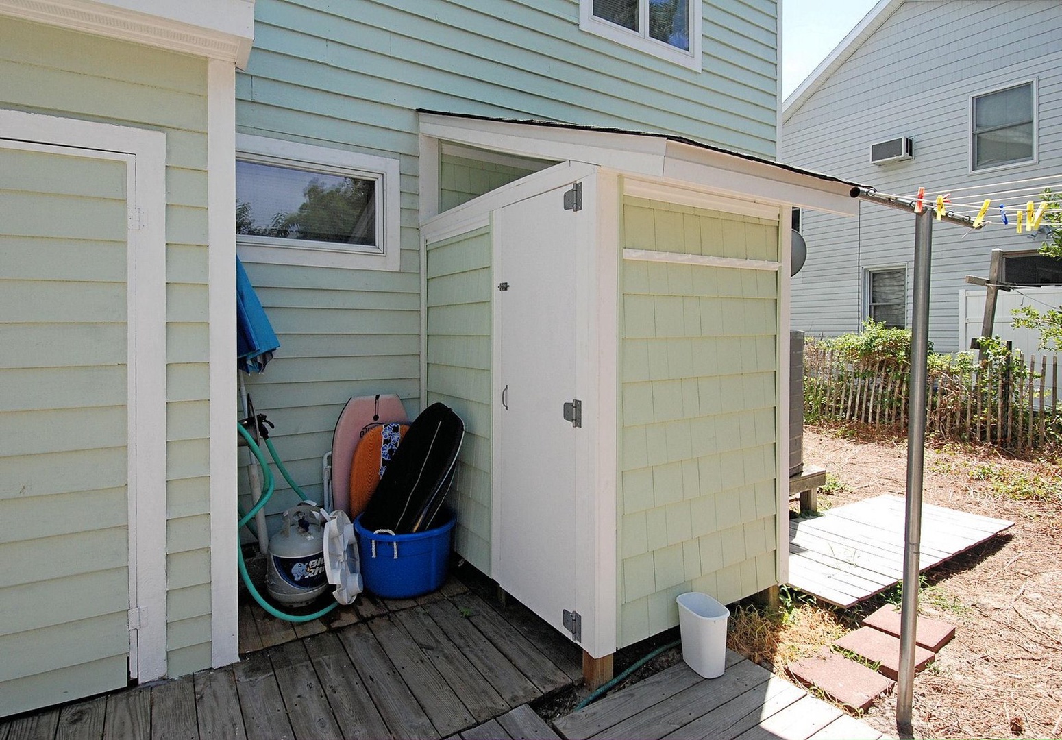 A private outdoor shower awaits you after beach days, tucked neatly between the house and backyard with storage for your gear nearby.