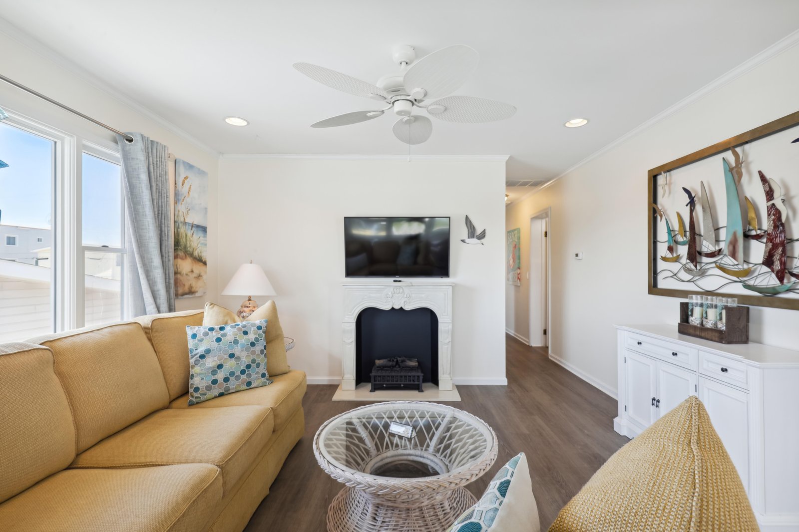 Relax in your bright coastal living room with comfortable seating, soothing beach-inspired decor, and a cozy fireplace to unwind after sunny days exploring the shore.
