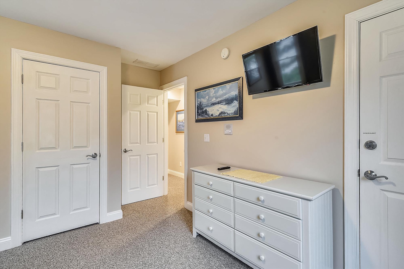 Your room features a sleek flat-screen TV and a spacious white dresser, perfect for unwinding after a day of adventure.