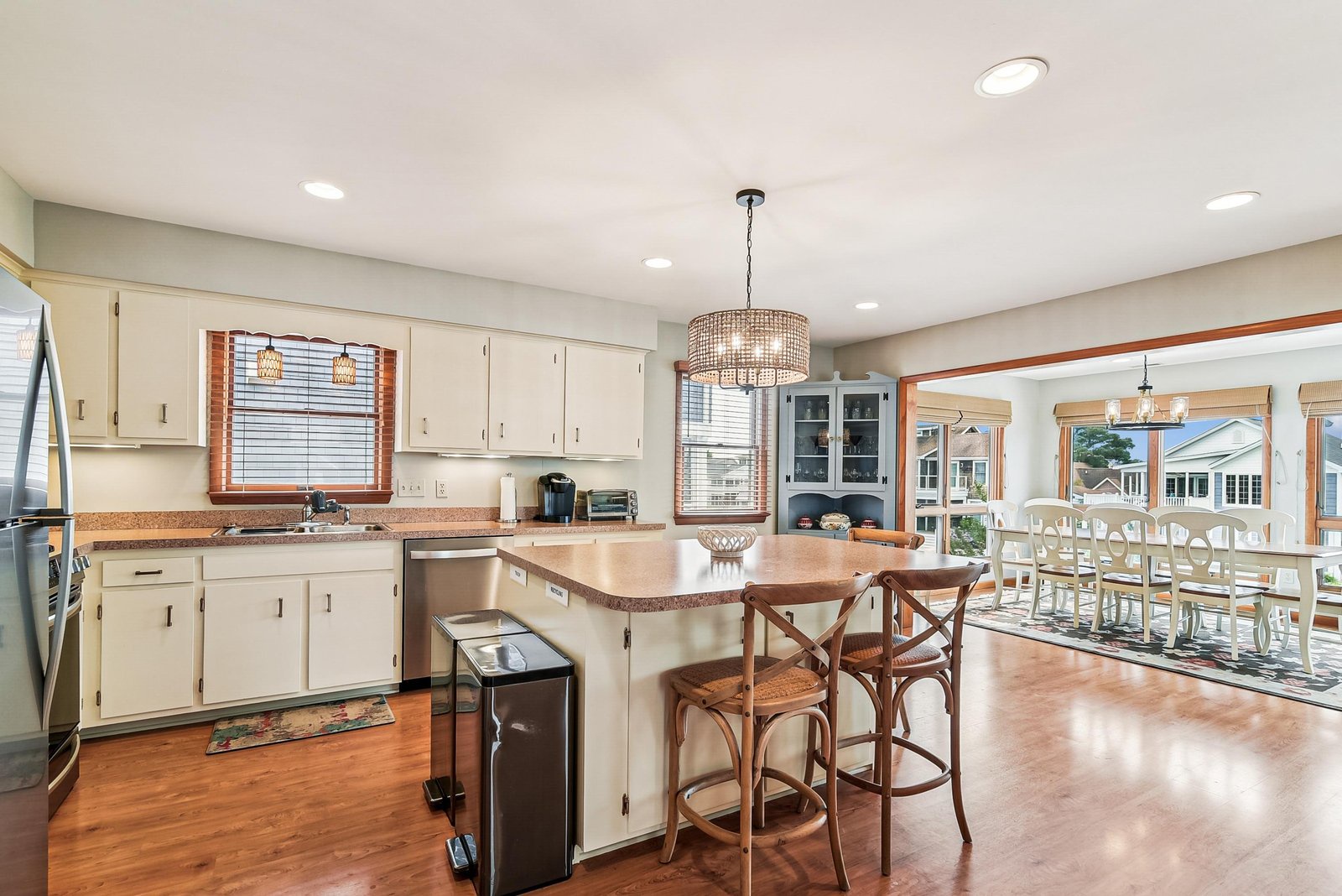 Step into this bright, open-concept kitchen where warm wood floors and soft natural light create an inviting space for gathering and cooking together.