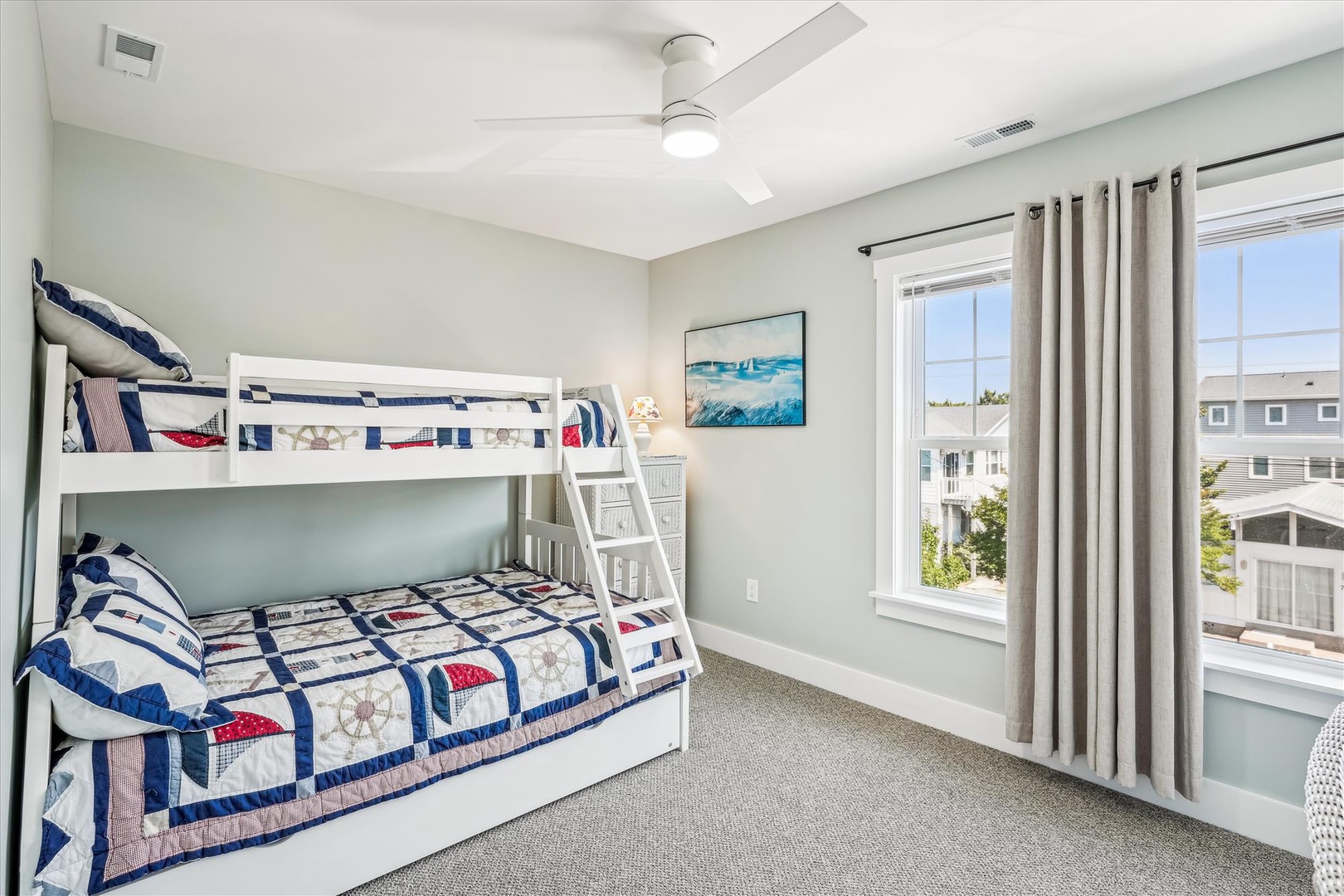 Your kids will love this nautical-themed bunk room with twin-over-full beds, perfect for adventures and cozy nights under the ceiling fan's gentle breeze.