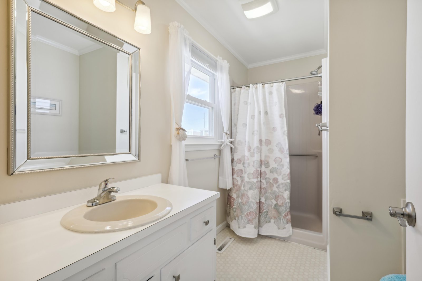 Freshen up in your private bathroom, where natural light streams through the window and soft towels await after a relaxing shower.