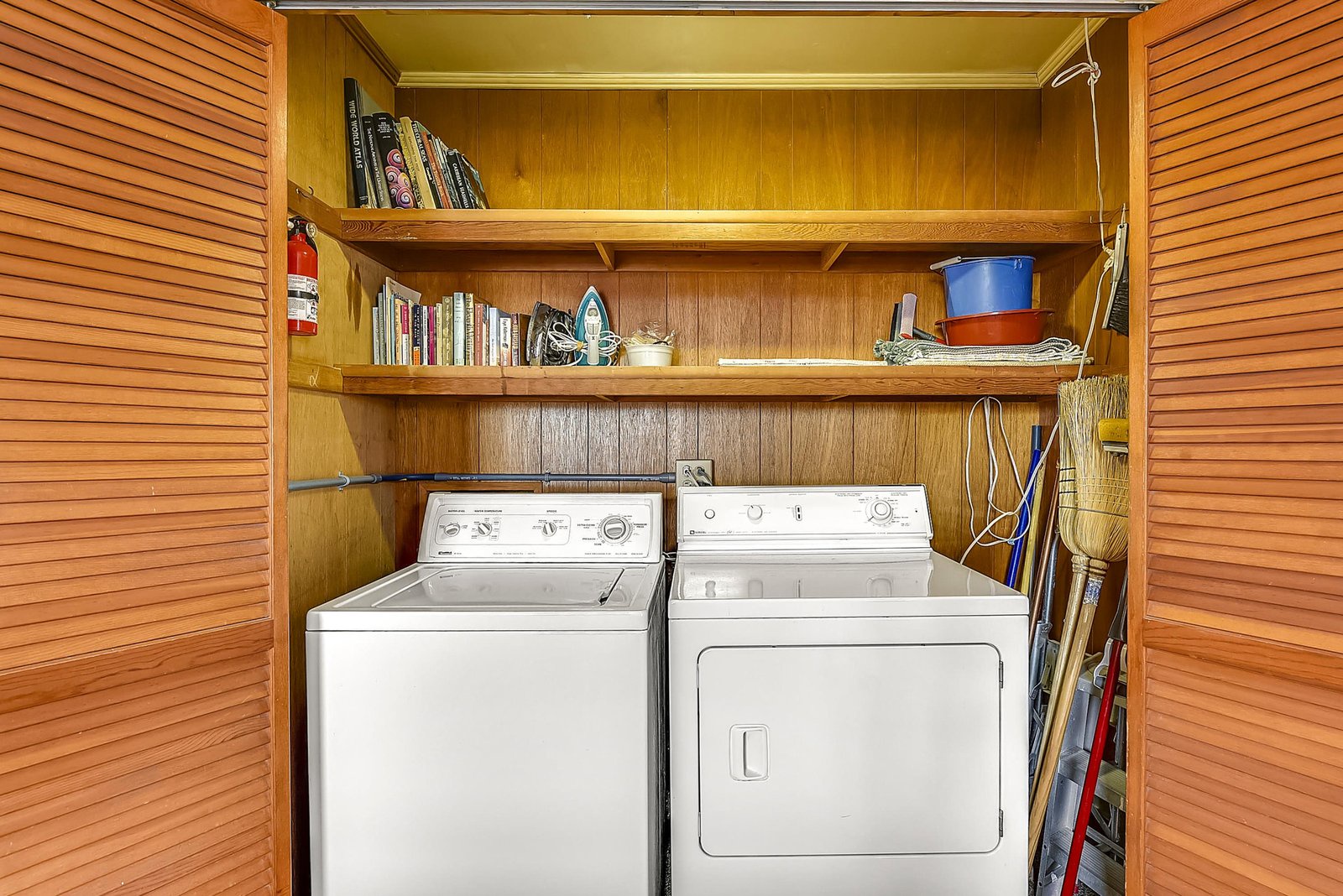 This dedicated laundry area keeps your wardrobe fresh and ready, with a washer and dryer conveniently tucked into wooden cabinetry along with extra storage for your essentials.